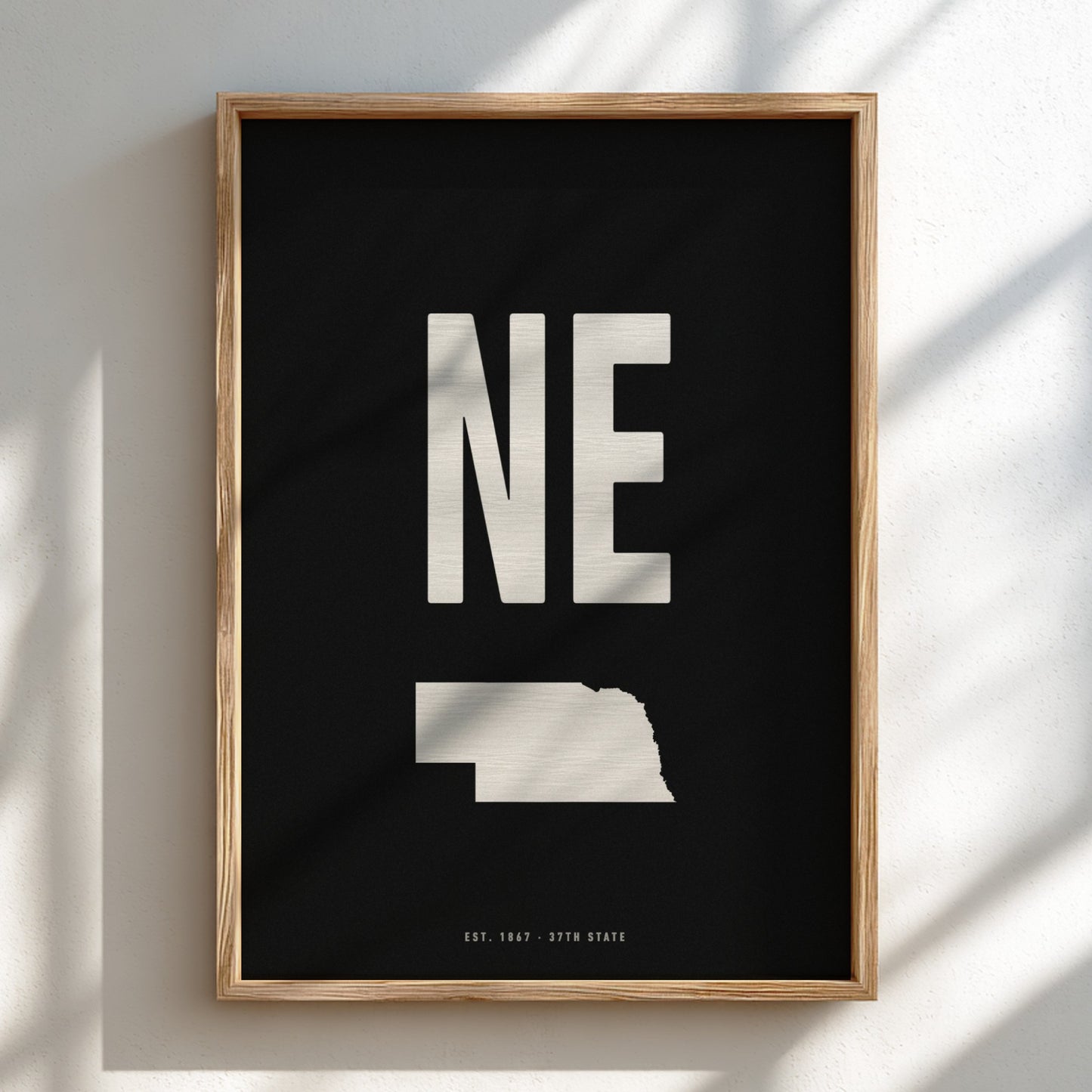 Framed artwork with 'NE' and a map of Nebraska on a black background