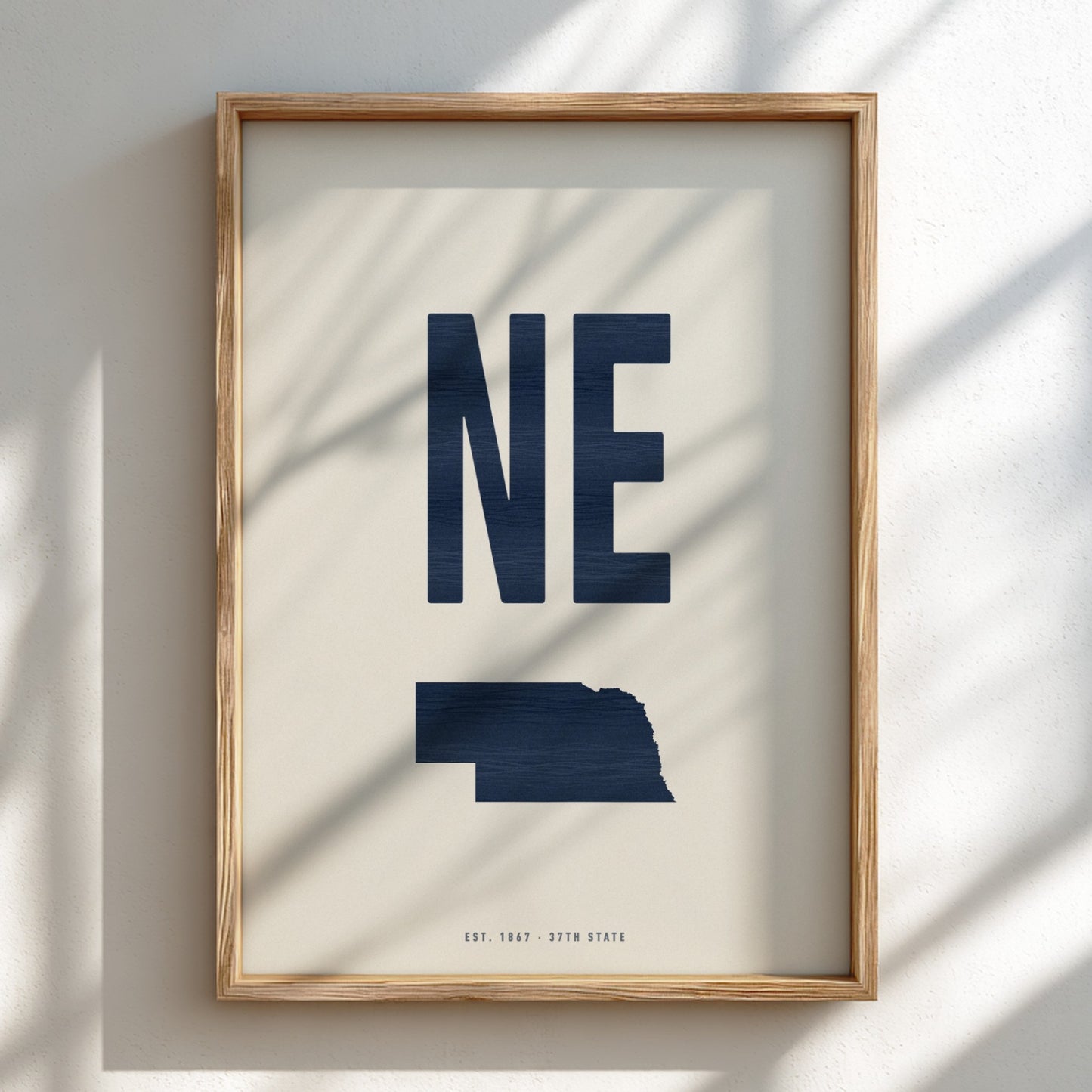Framed artwork with 'NE' and a map of Nebraska on a light background