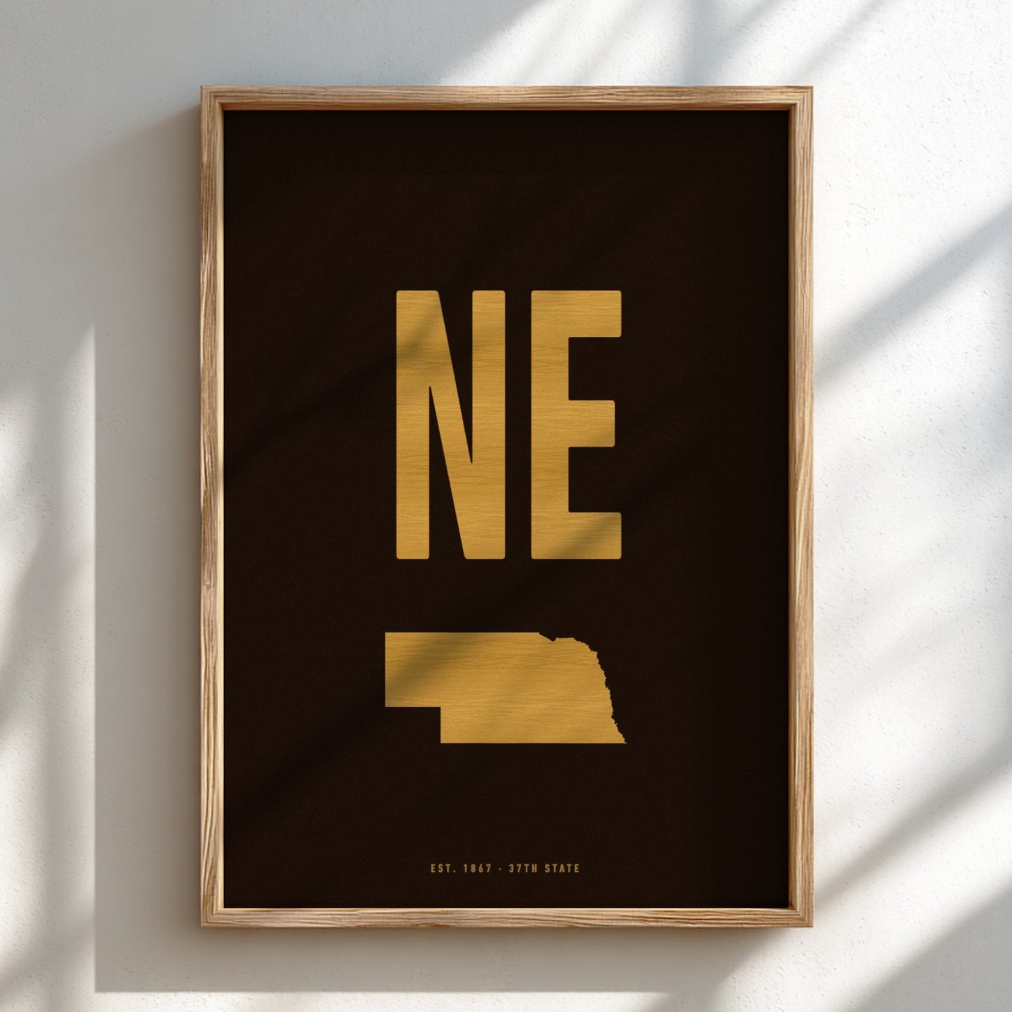 Framed artwork with 'NE' in gold on a black background