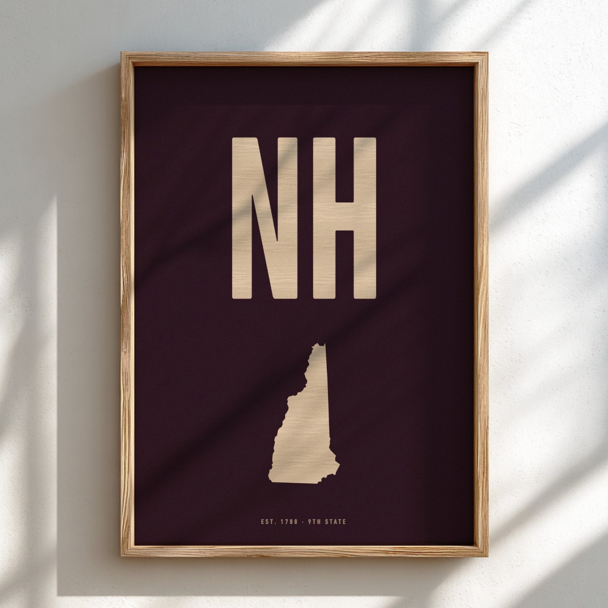 Framed artwork with 'NH' and a map outline on a dark background
