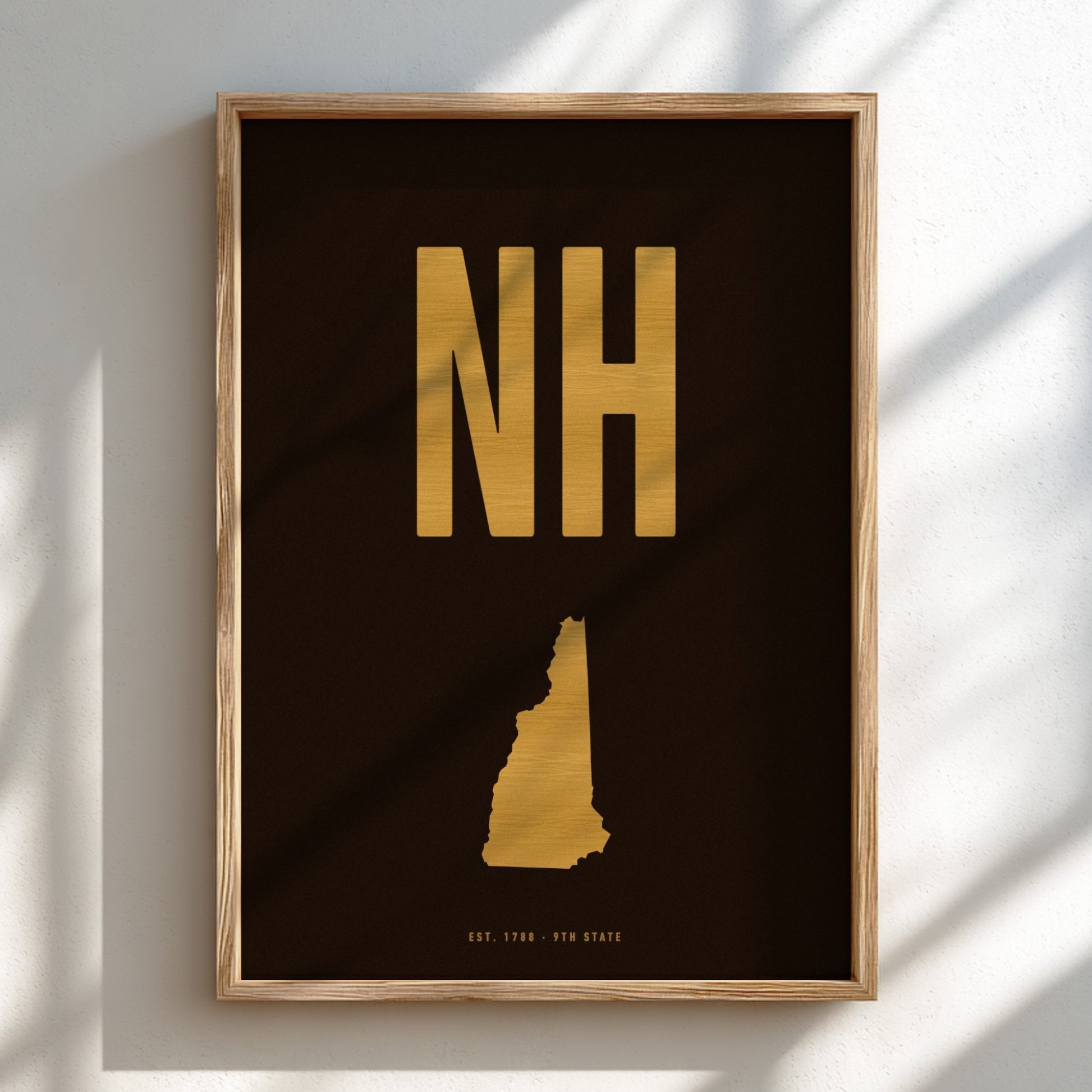 Framed artwork with 'NH' in gold on a black background