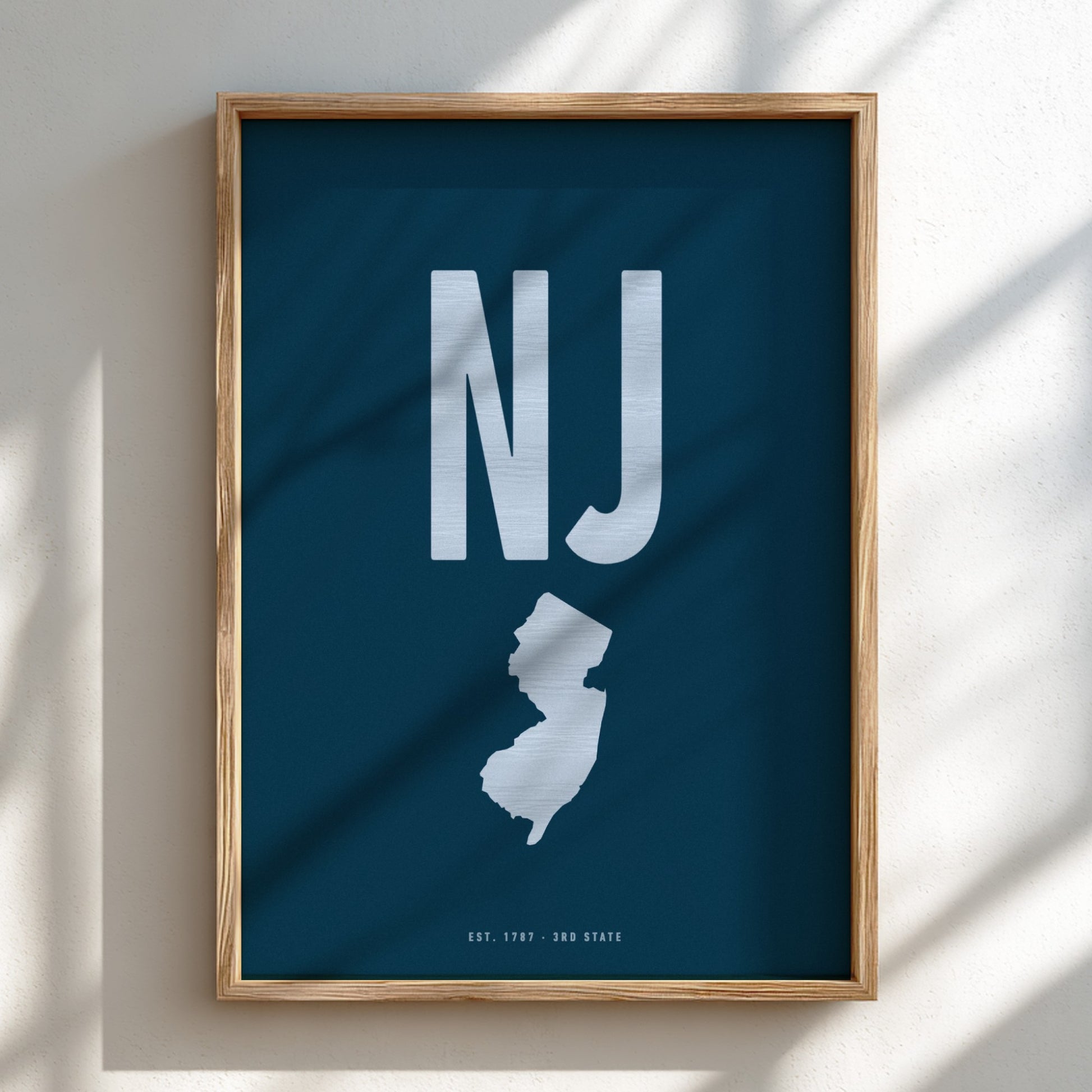 Framed poster with 'NJ' and outline of New Jersey on a blue background