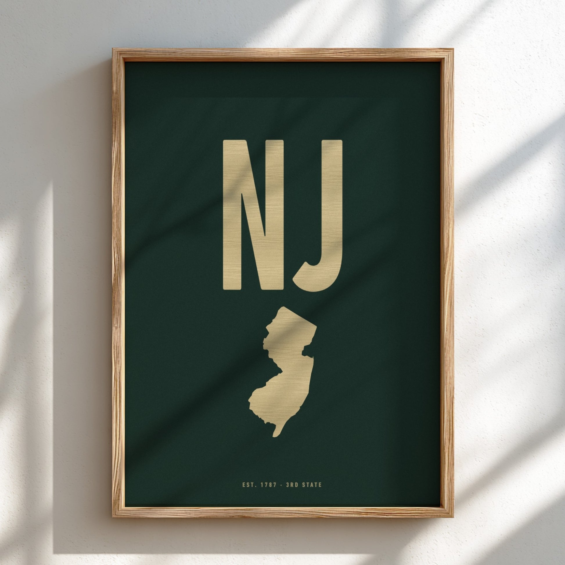 Framed poster with 'NJ' in gold on a dark green background