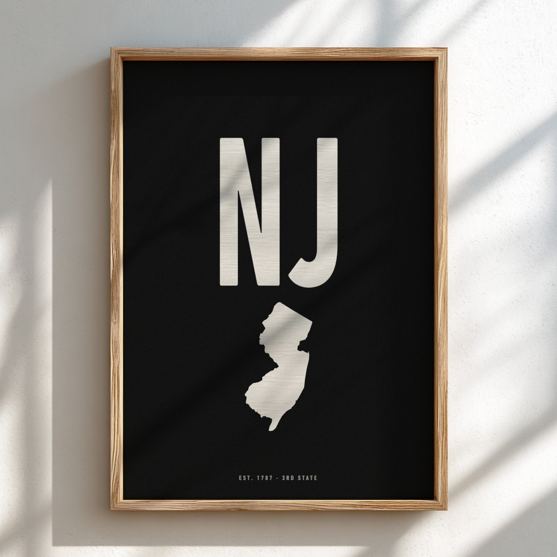 Framed poster with 'NJ' and outline of New Jersey on a black background