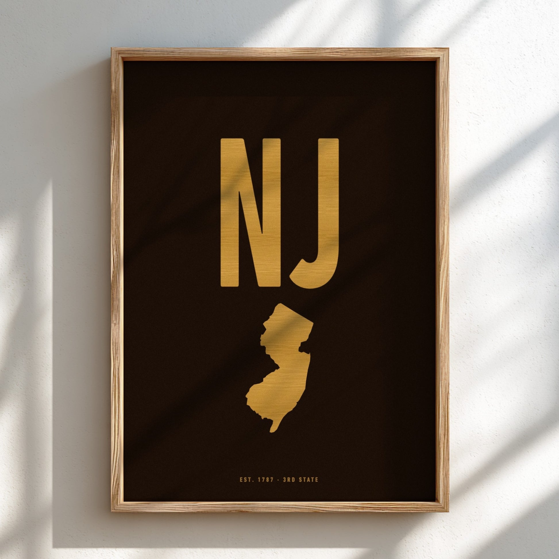 Framed artwork with 'NJ' in gold on a dark background