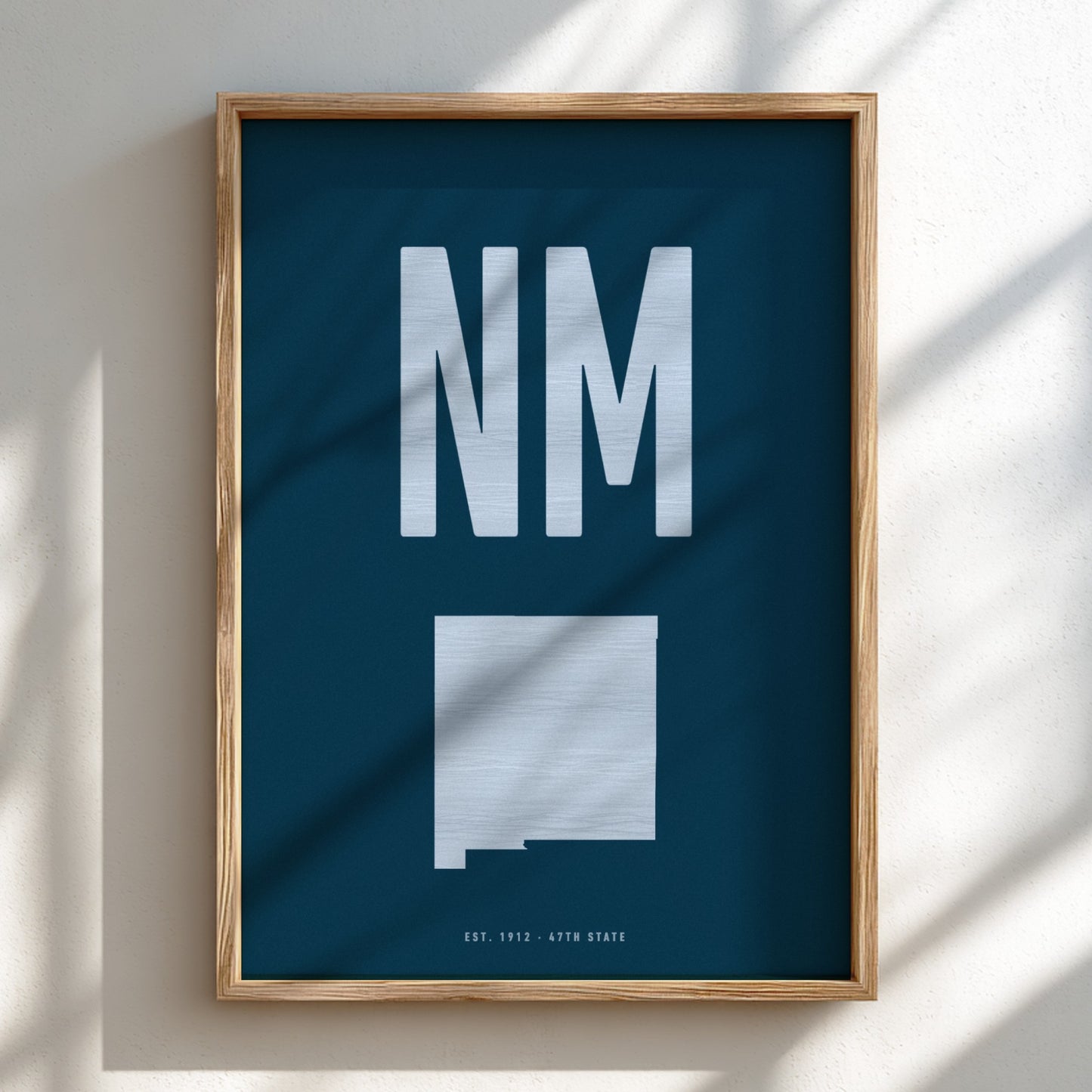 Framed poster with 'NM' and a map of New Mexico on a blue background