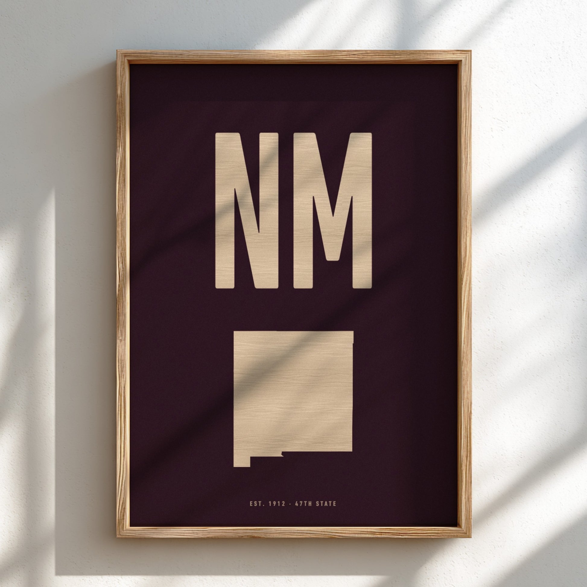 Framed artwork with 'NM' and a map of New Mexico on a dark background