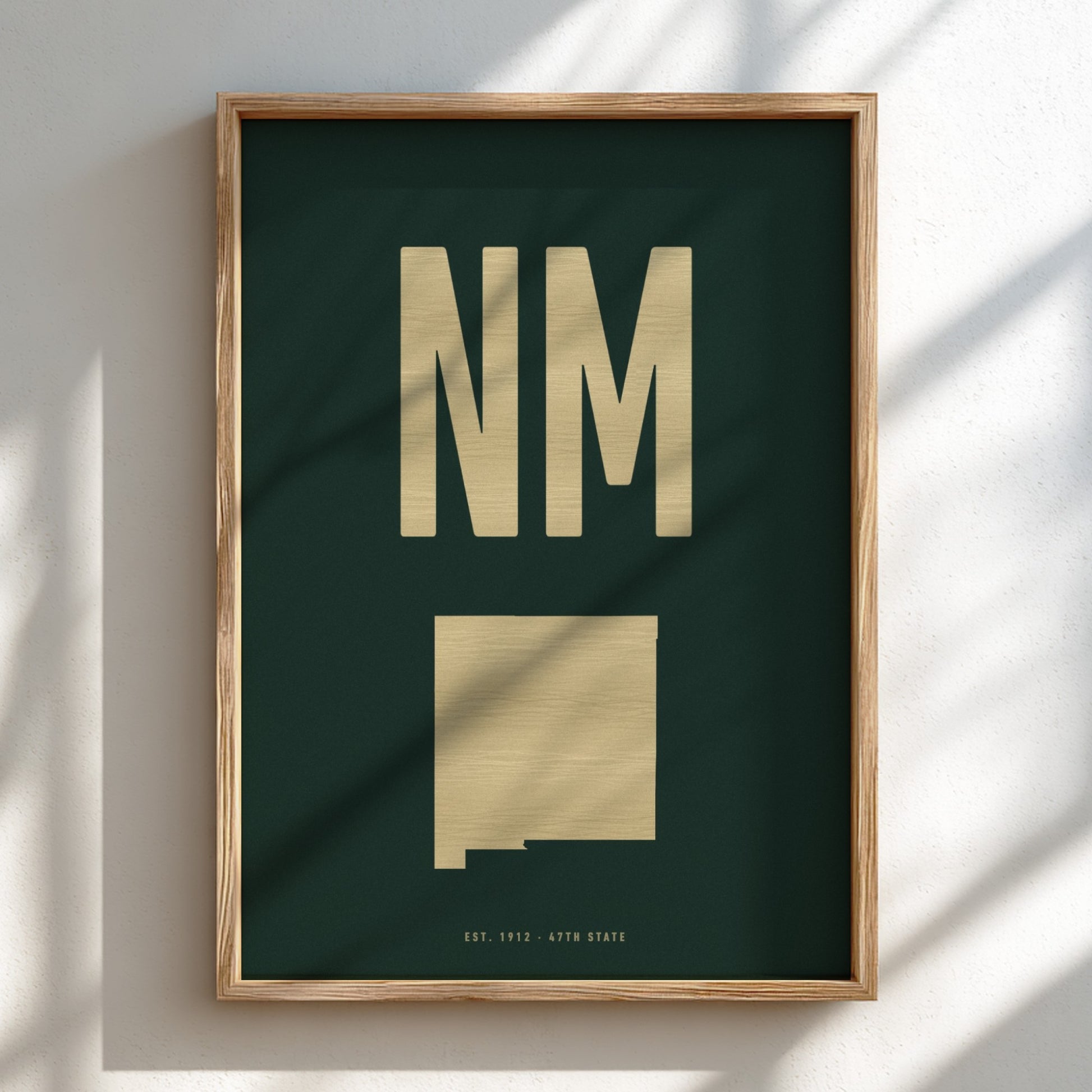 Framed poster with 'NM' and a map of New Mexico on a dark green background