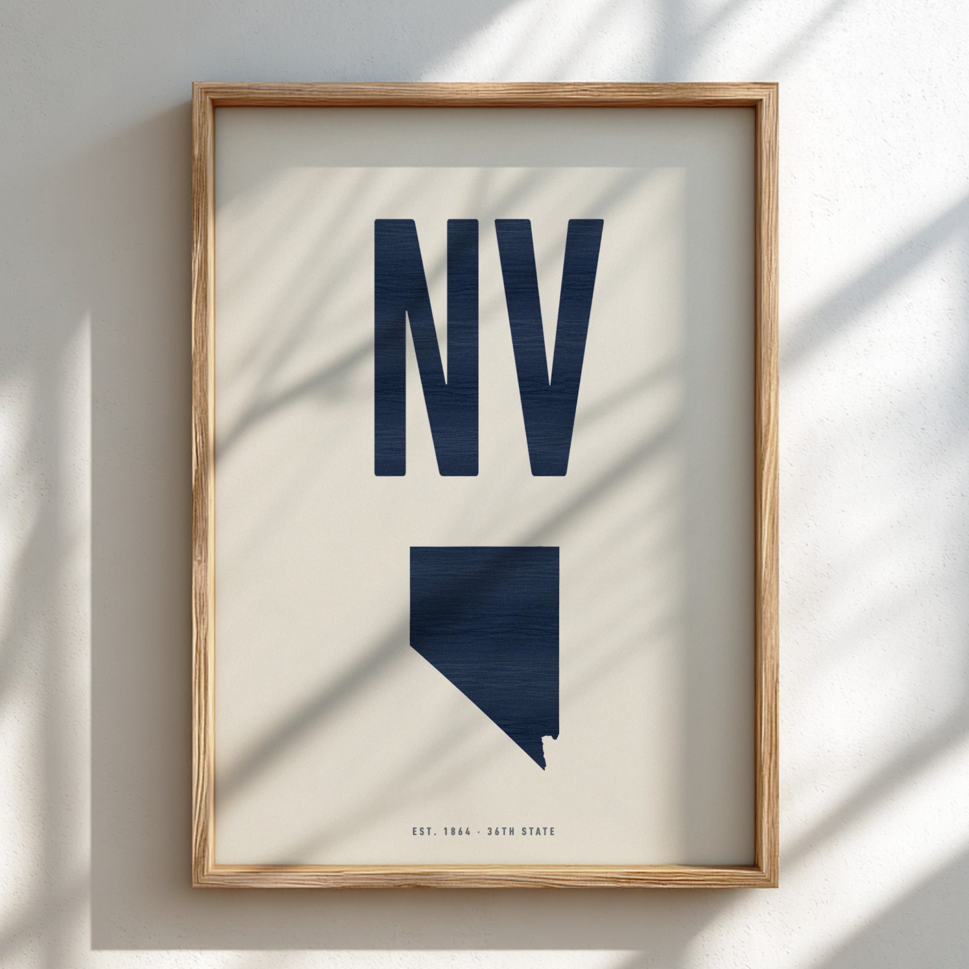 Framed artwork with 'NV' and a map of Nevada on a light background