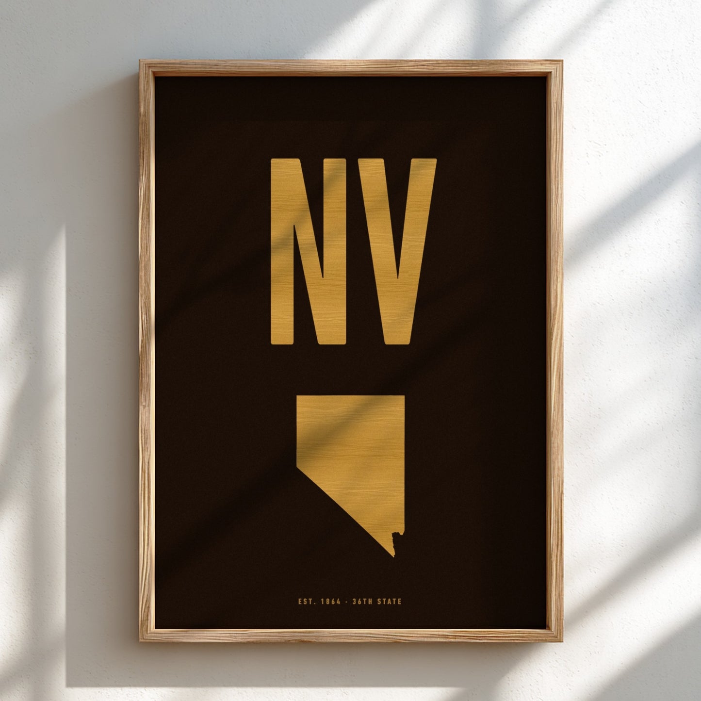 Framed artwork with gold 'NV' and state outline on a black background