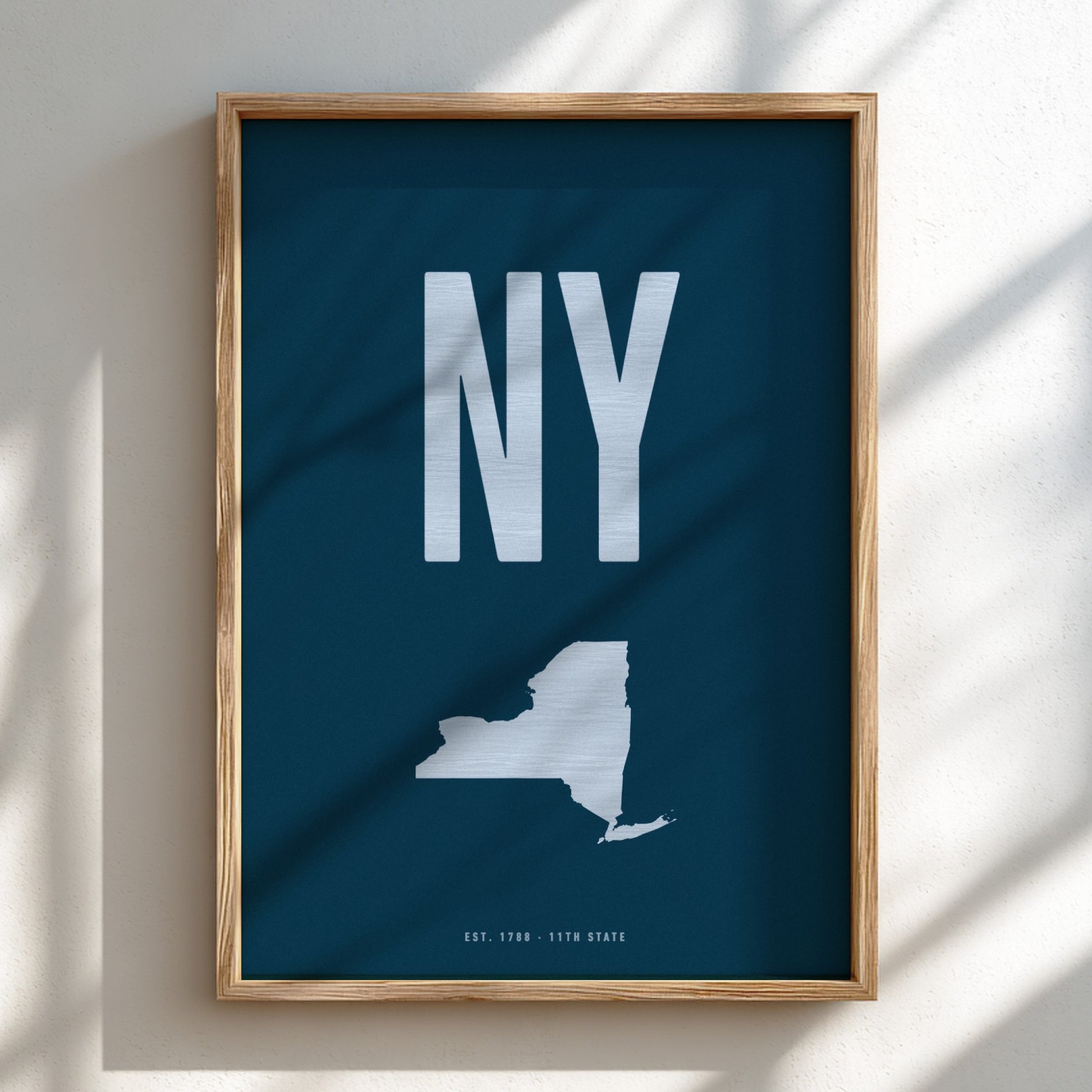Framed poster with 'NY' and a map of New York state on a blue background