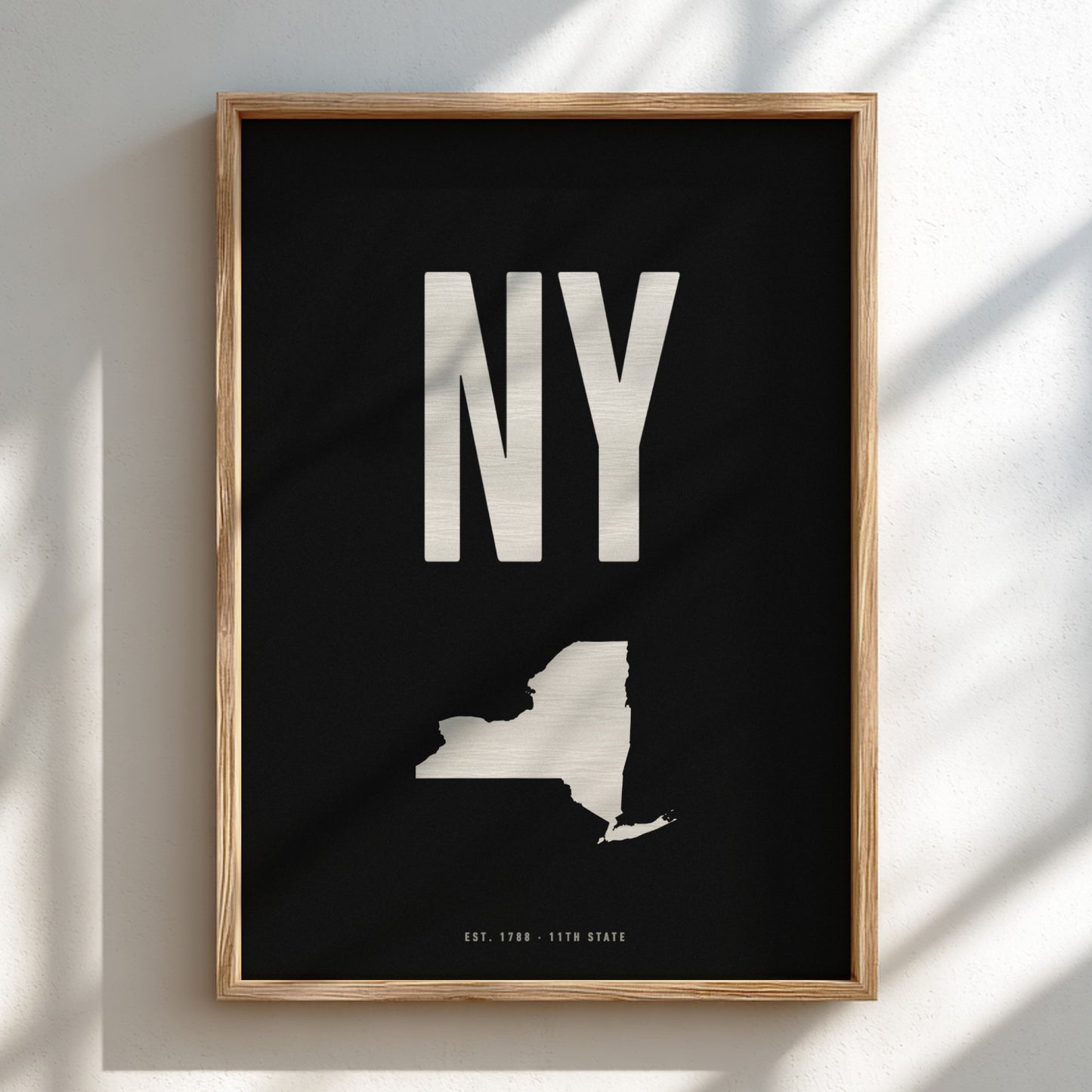 Framed poster with 'NY' and a map of New York state on a black background
