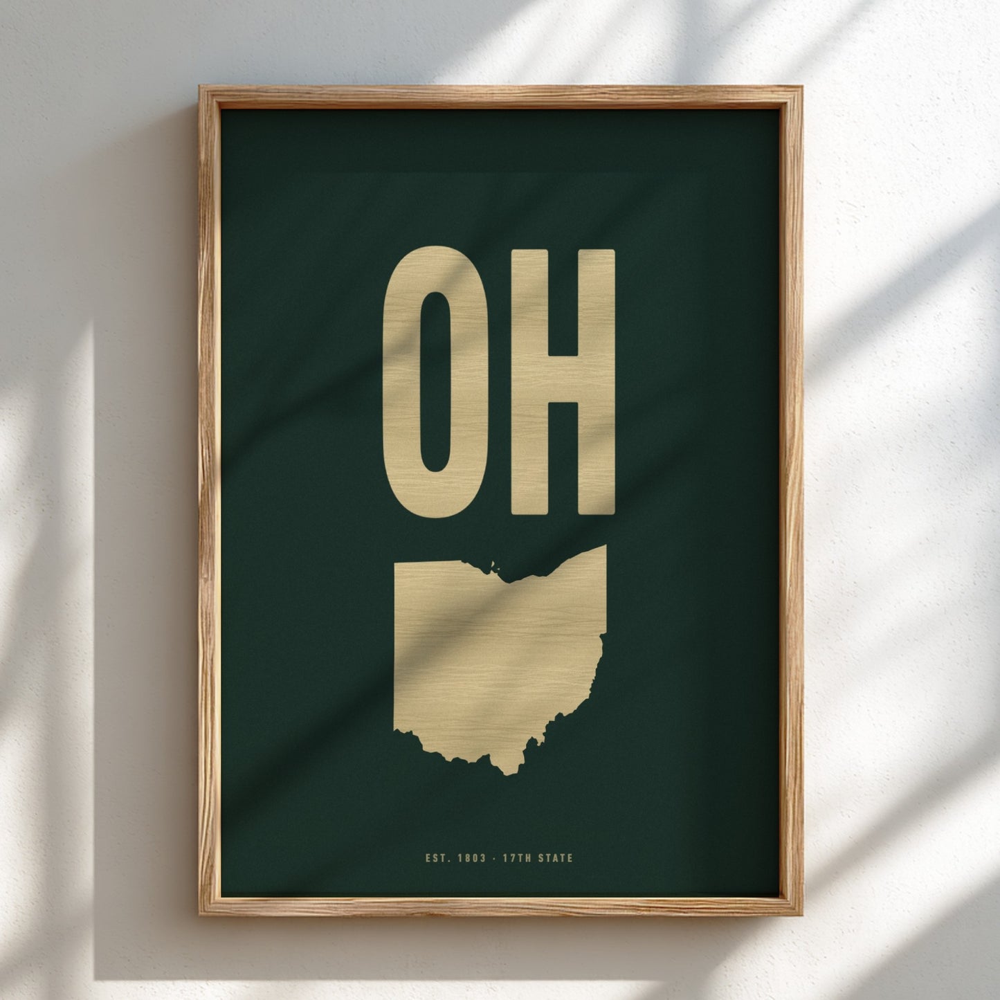 Framed artwork with gold 'OH' on a dark green background