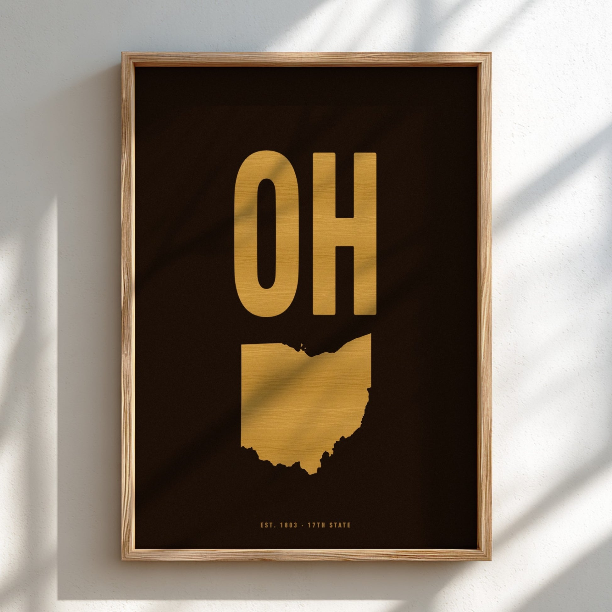 Framed artwork with gold state outline and 'OH' on a black background