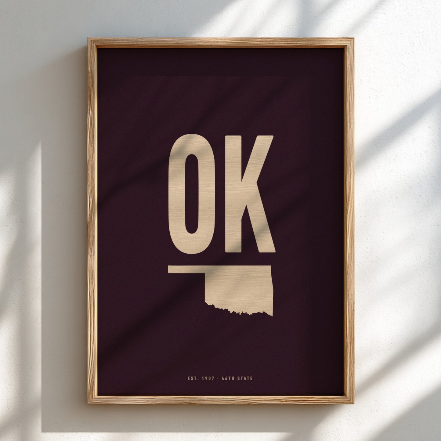Framed artwork with 'OK' and outline of Oklahoma on a dark background