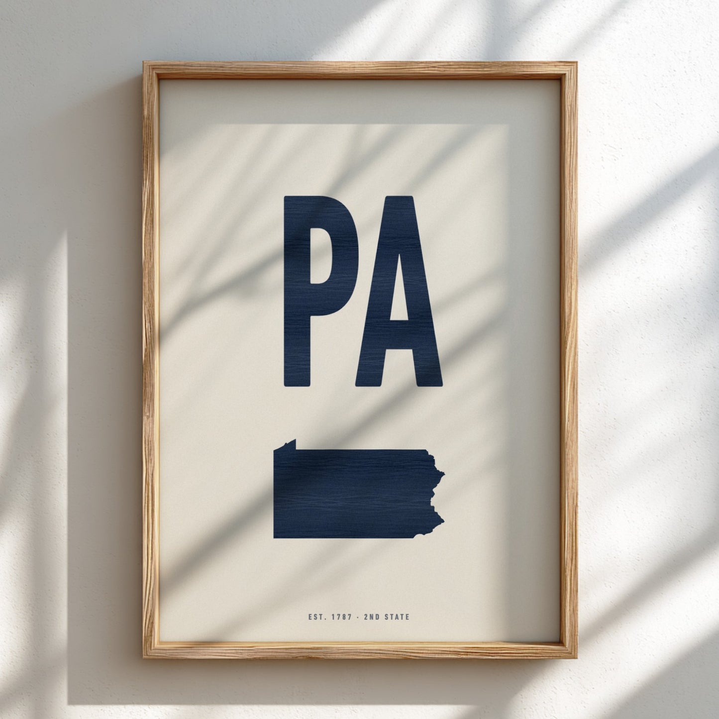 Framed artwork with 'PA' in navy on a light background