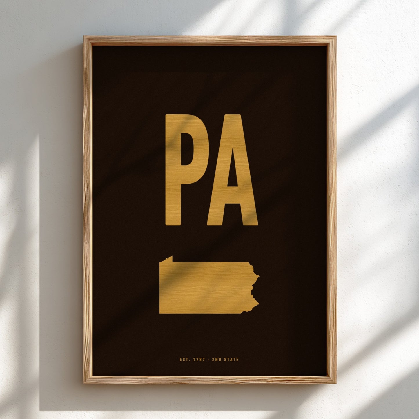Framed artwork with gold state outline and 'PA' on a black background