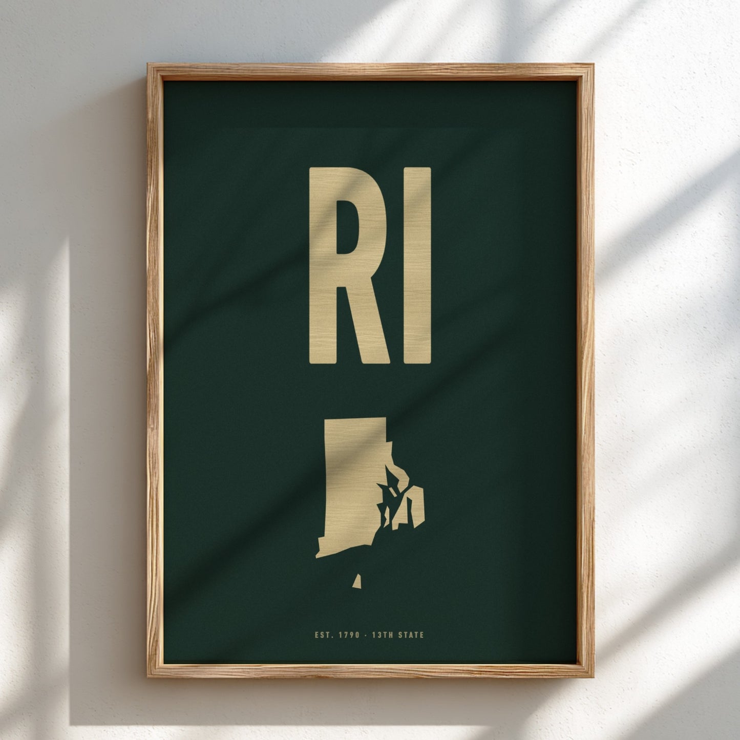Framed artwork with 'RI' and state silhouette on a dark green background