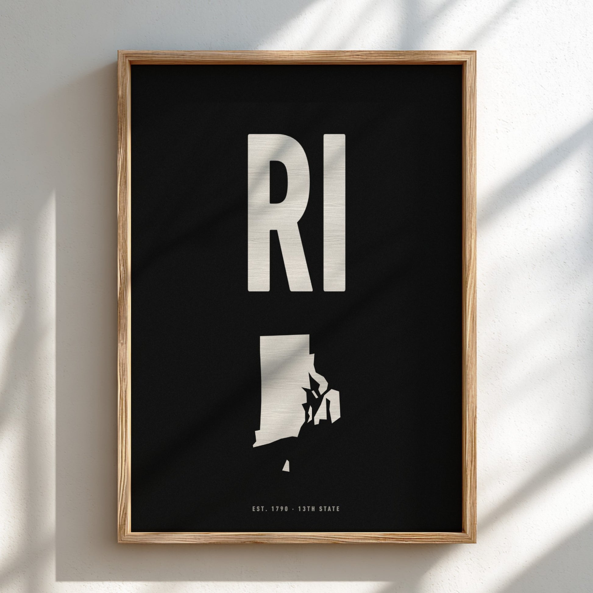 Framed artwork with 'RI' and silhouette of Rhode Island on a black background