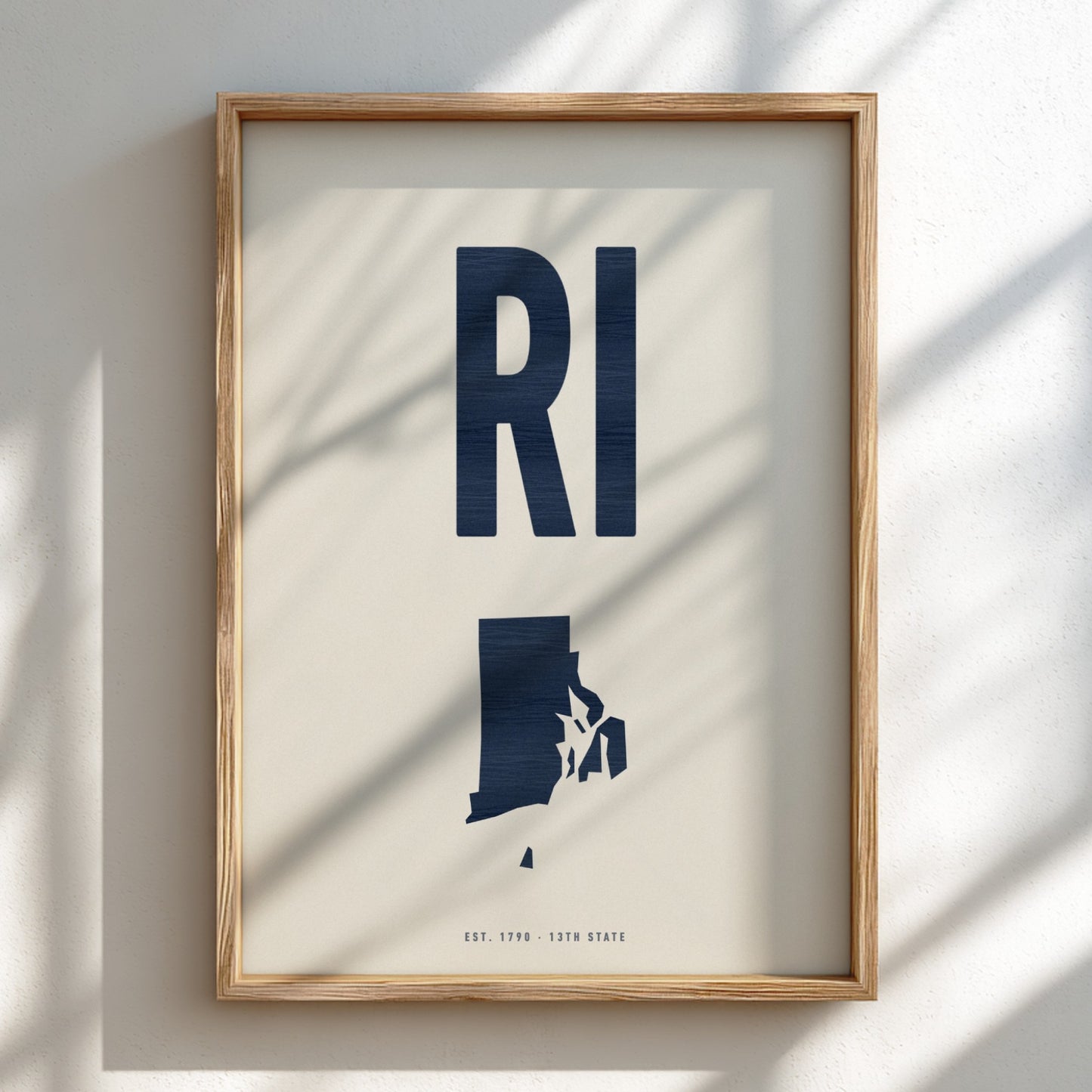 Framed artwork with 'RI' and state outline on a light background