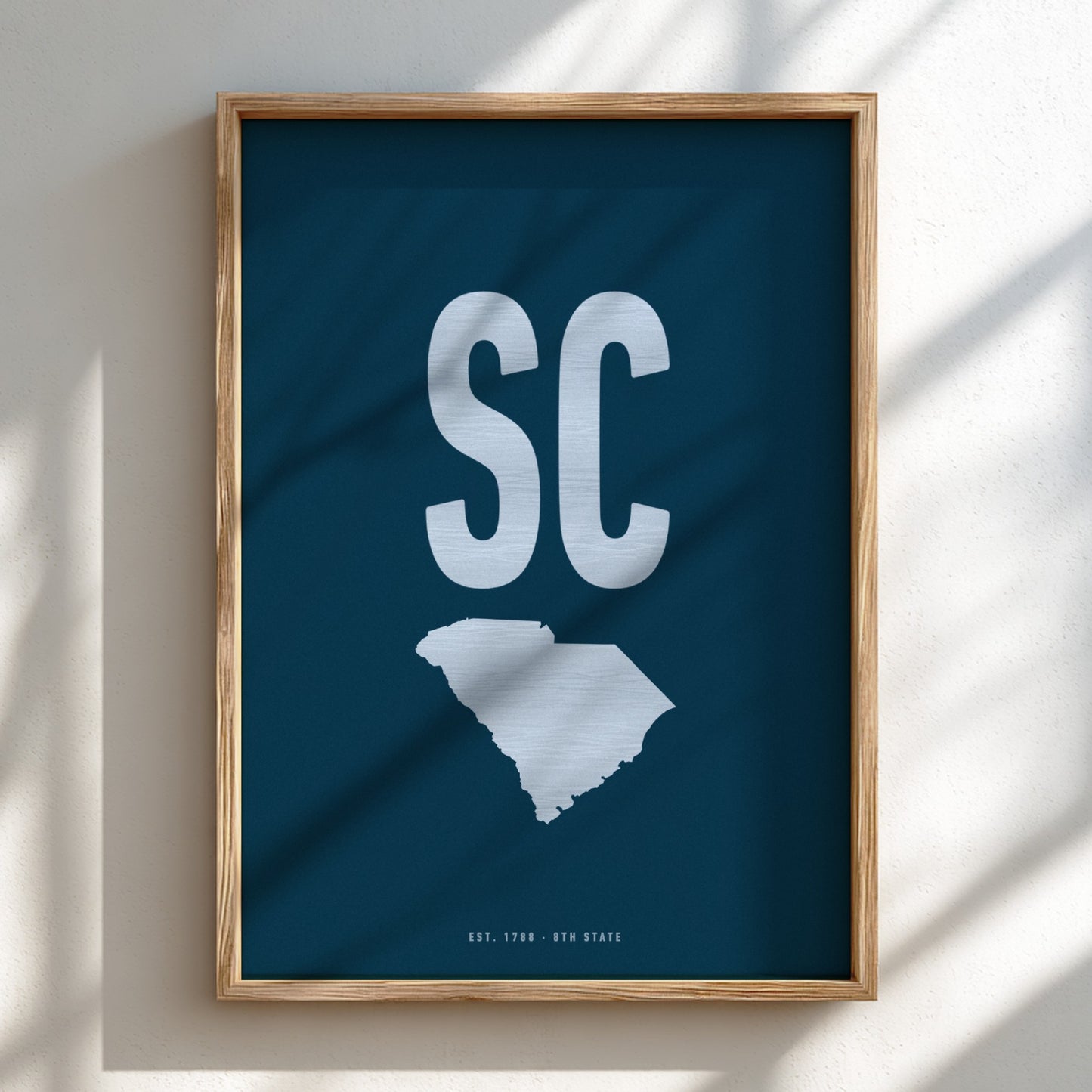Framed artwork with 'SC' and a map of South Carolina on a blue background