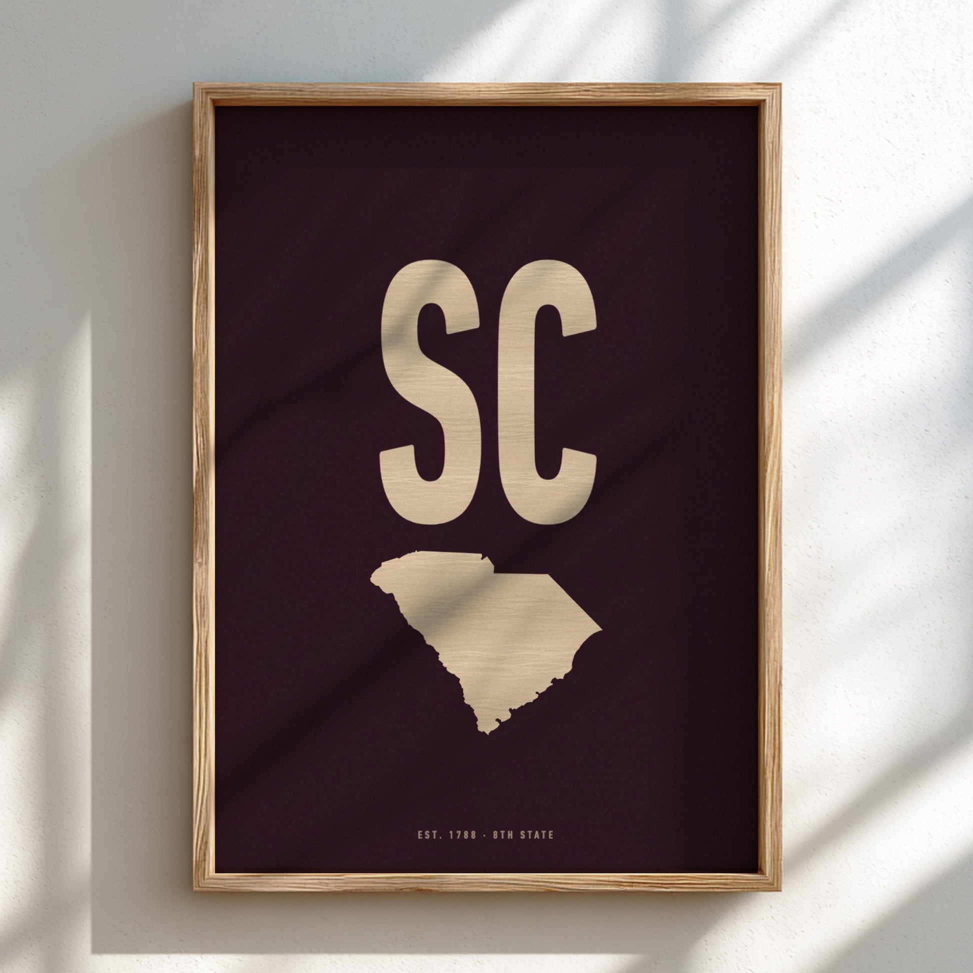 Framed artwork with 'SC' and a map of South Carolina on a dark background