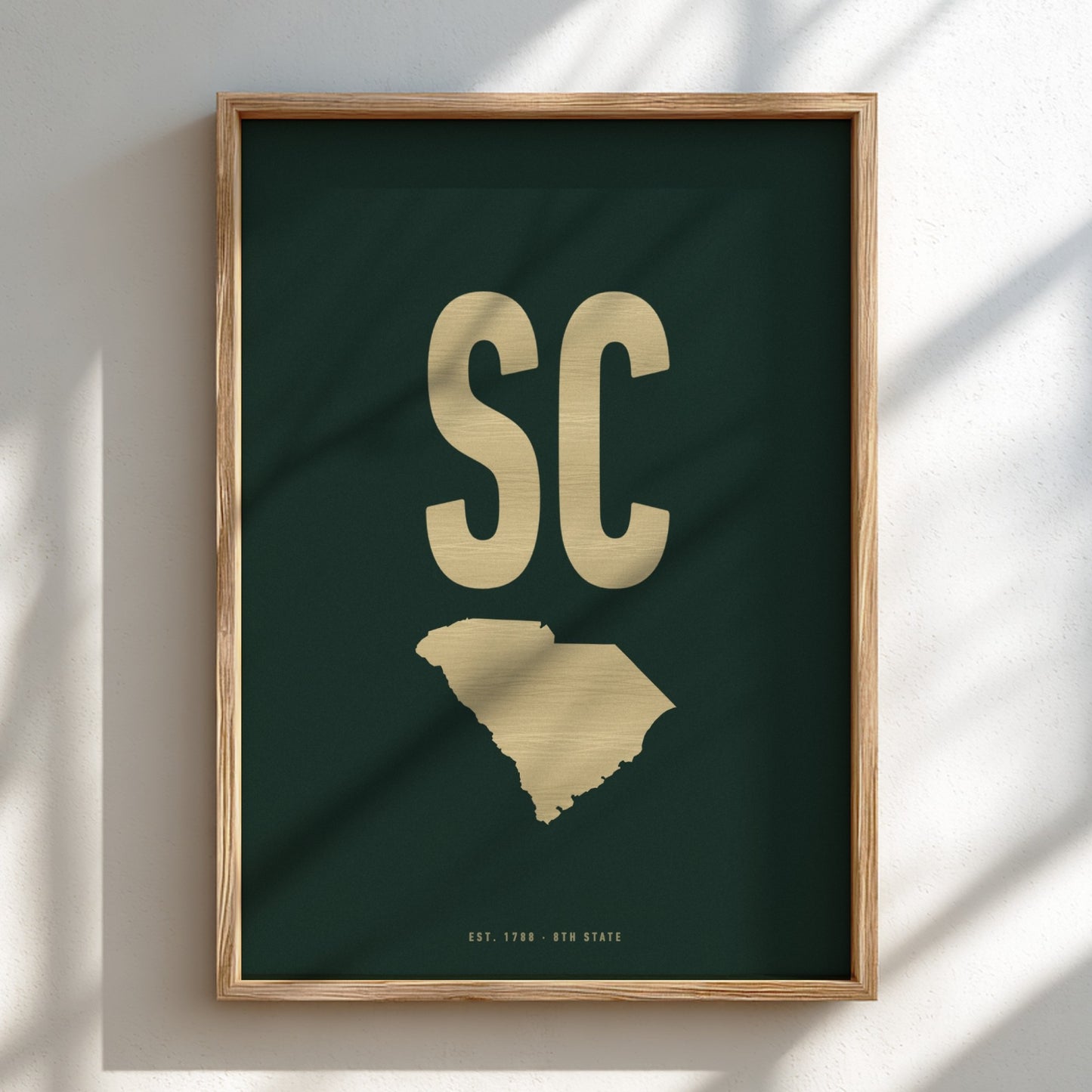 Framed artwork with 'SC' in gold on a dark green background