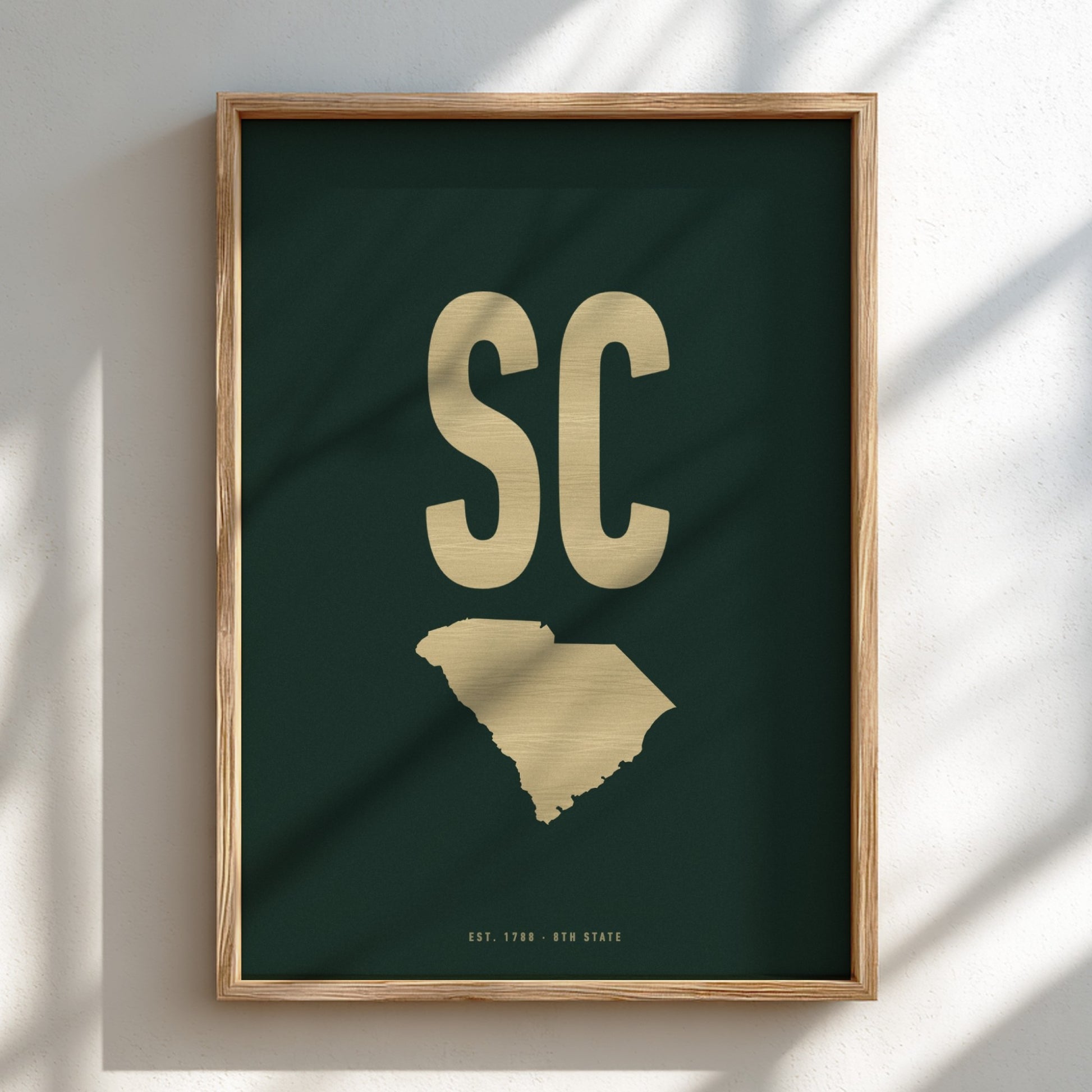Framed artwork with 'SC' in gold on a dark green background