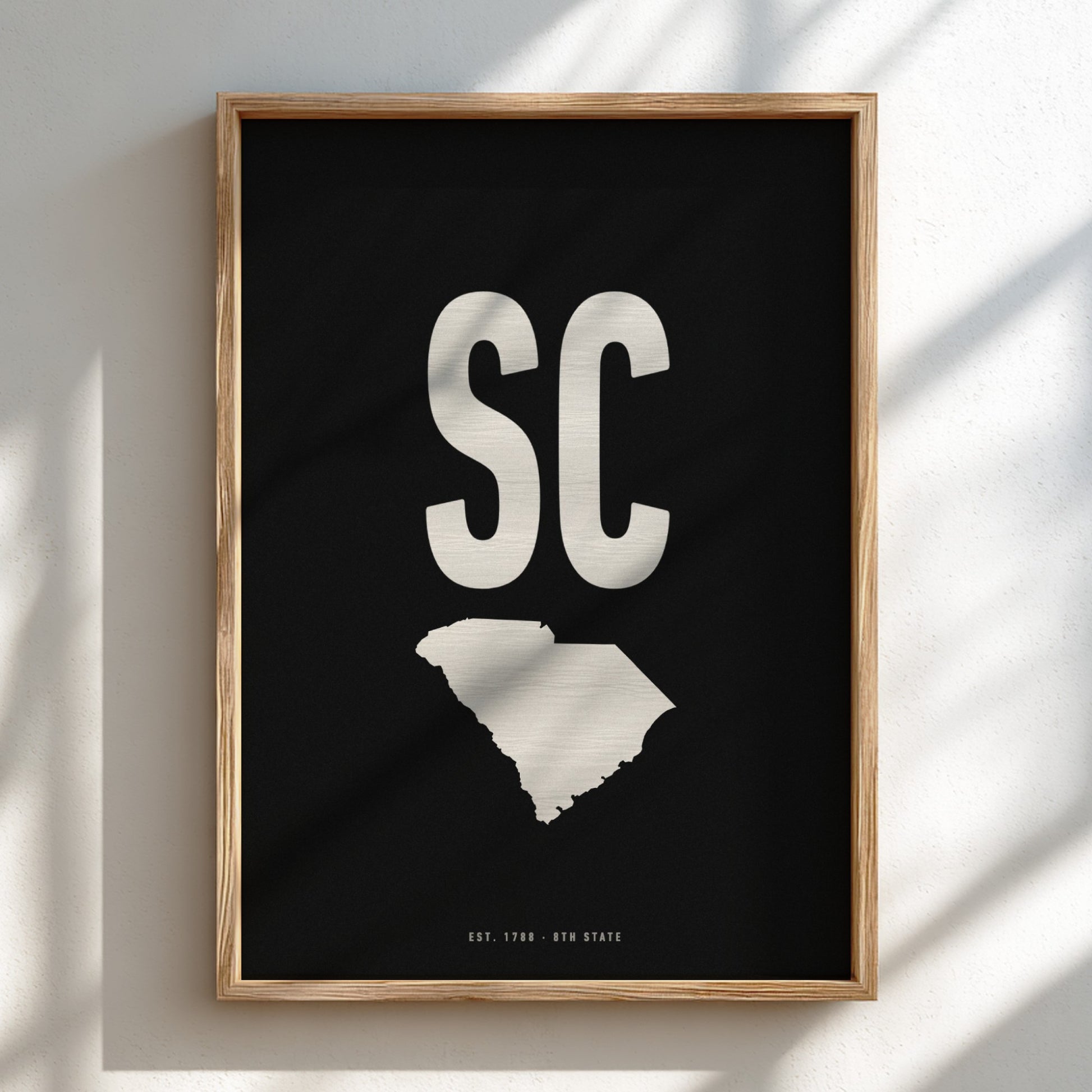 Framed poster with 'SC' and outline of South Carolina on a black background