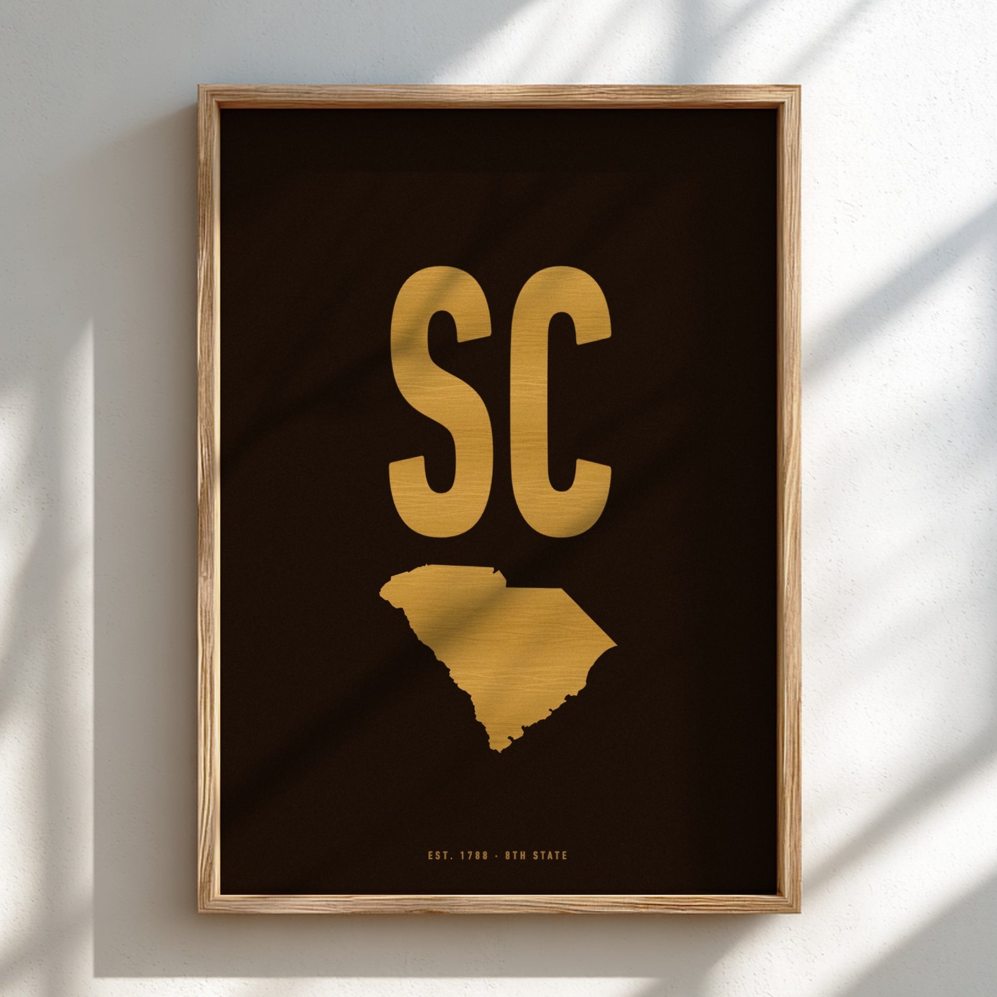 Framed artwork with 'SC' in gold on a dark background