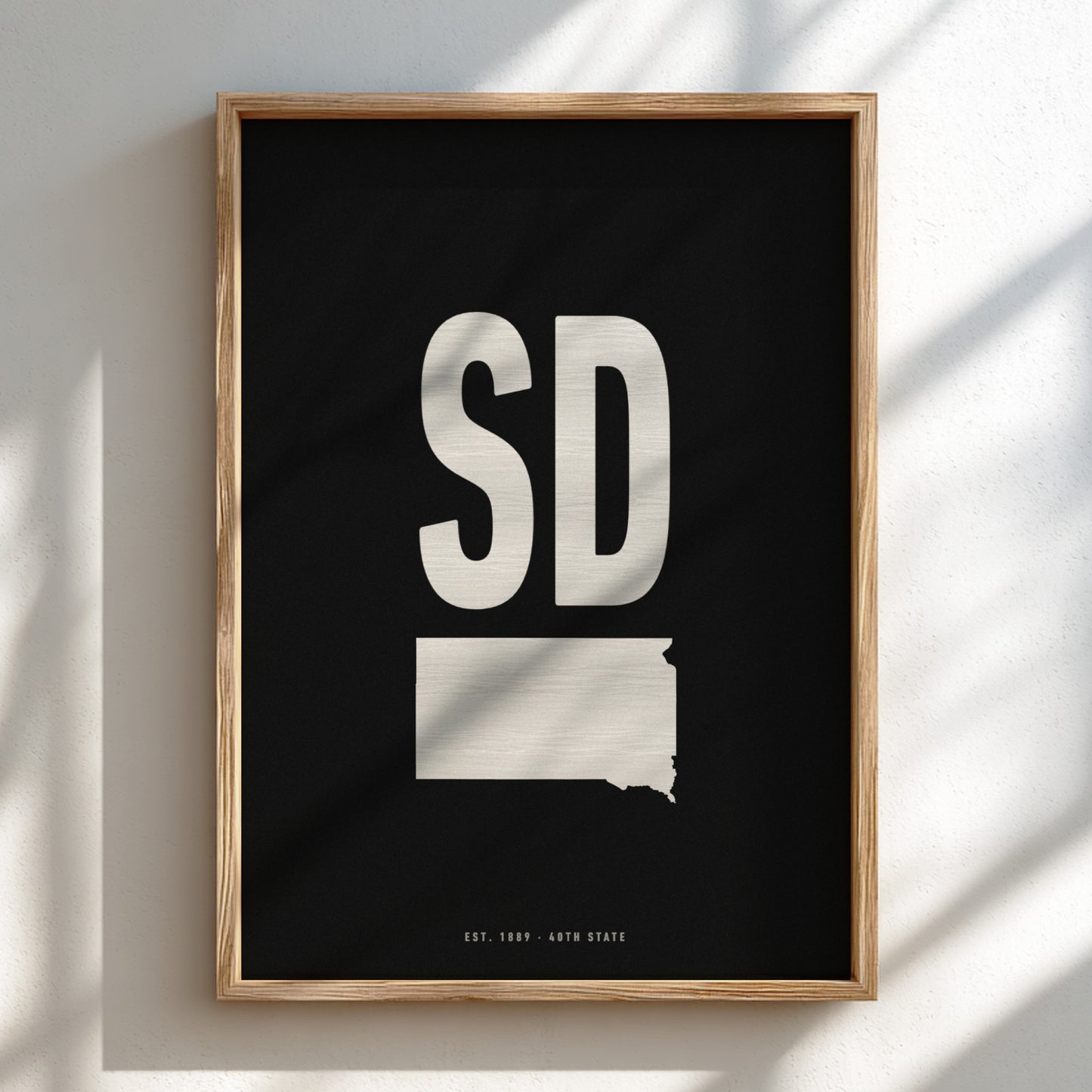 Framed artwork with 'SD' and a state outline on a black background