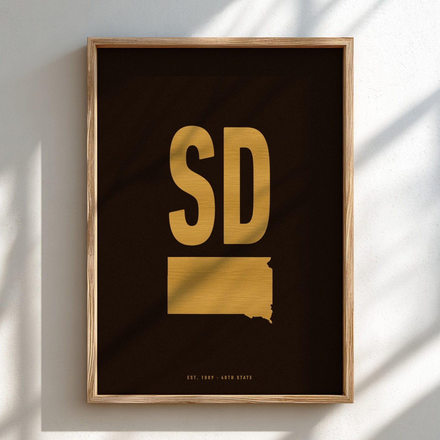Framed artwork with 'SD' in gold on a black background