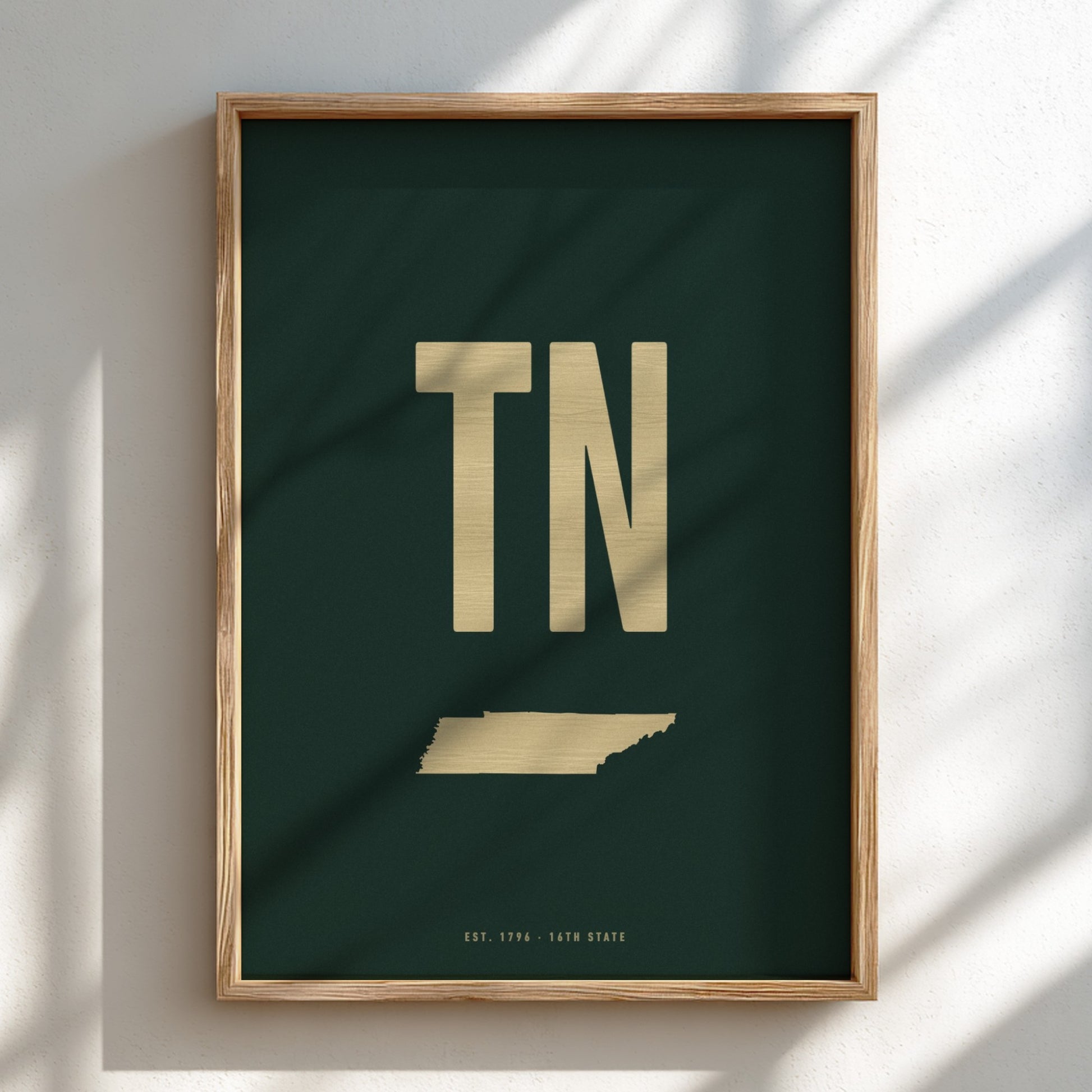 Framed poster with 'TN' in gold on a dark green background