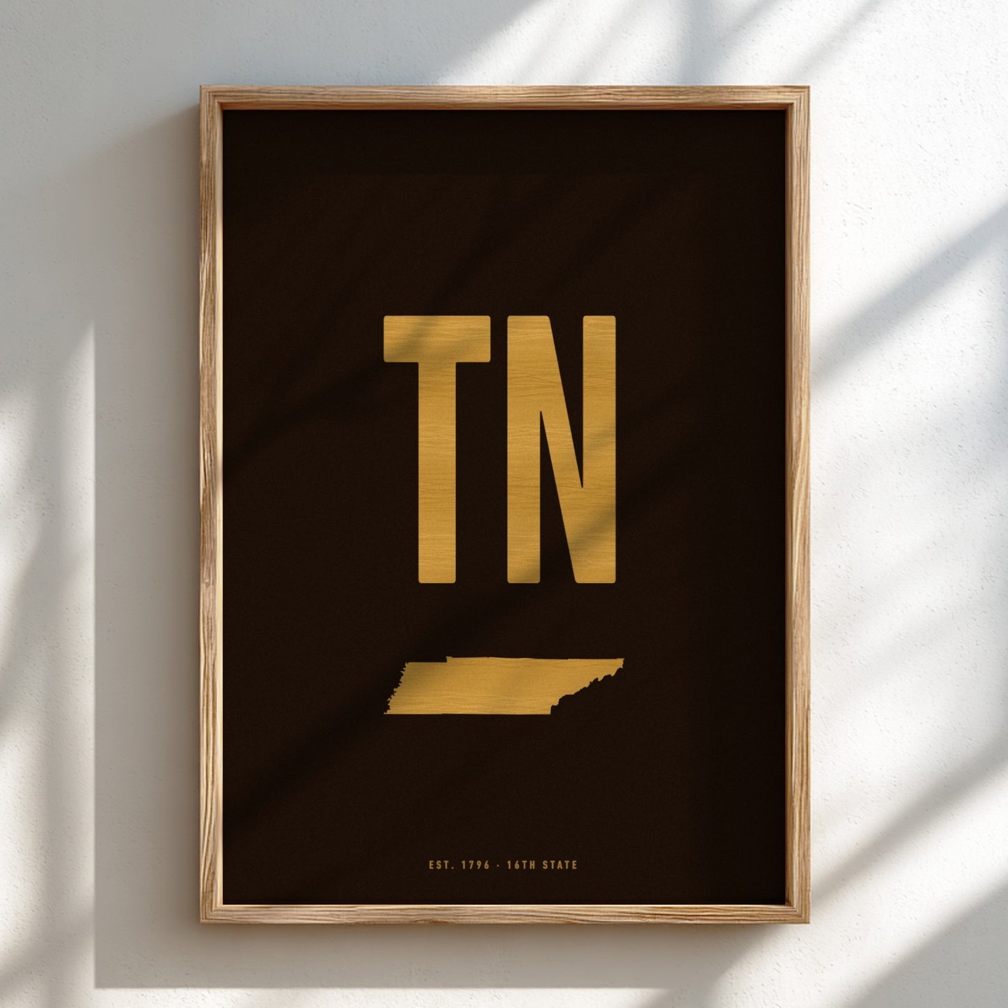 Framed artwork with 'TN' in gold on a black background