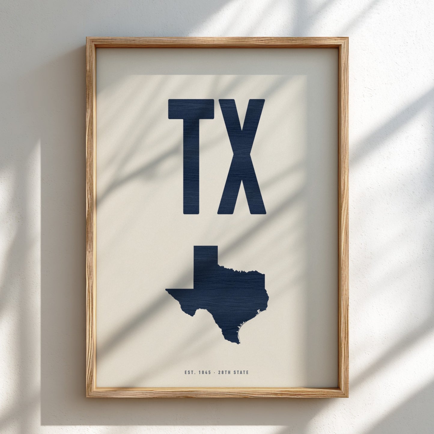 Framed artwork with 'TX' and a map of Texas on a light background