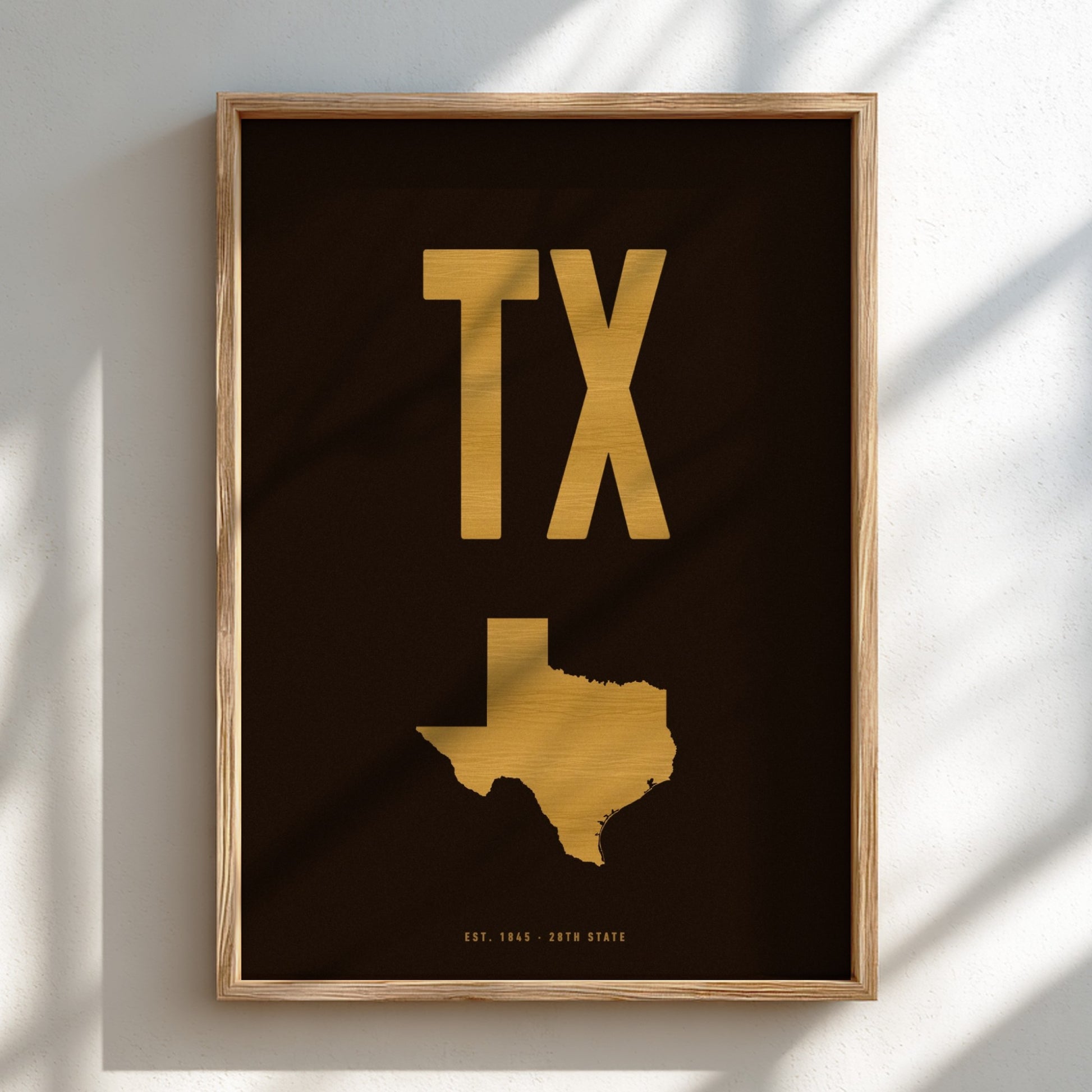 Framed artwork with gold 'TX' and Texas map on a dark background