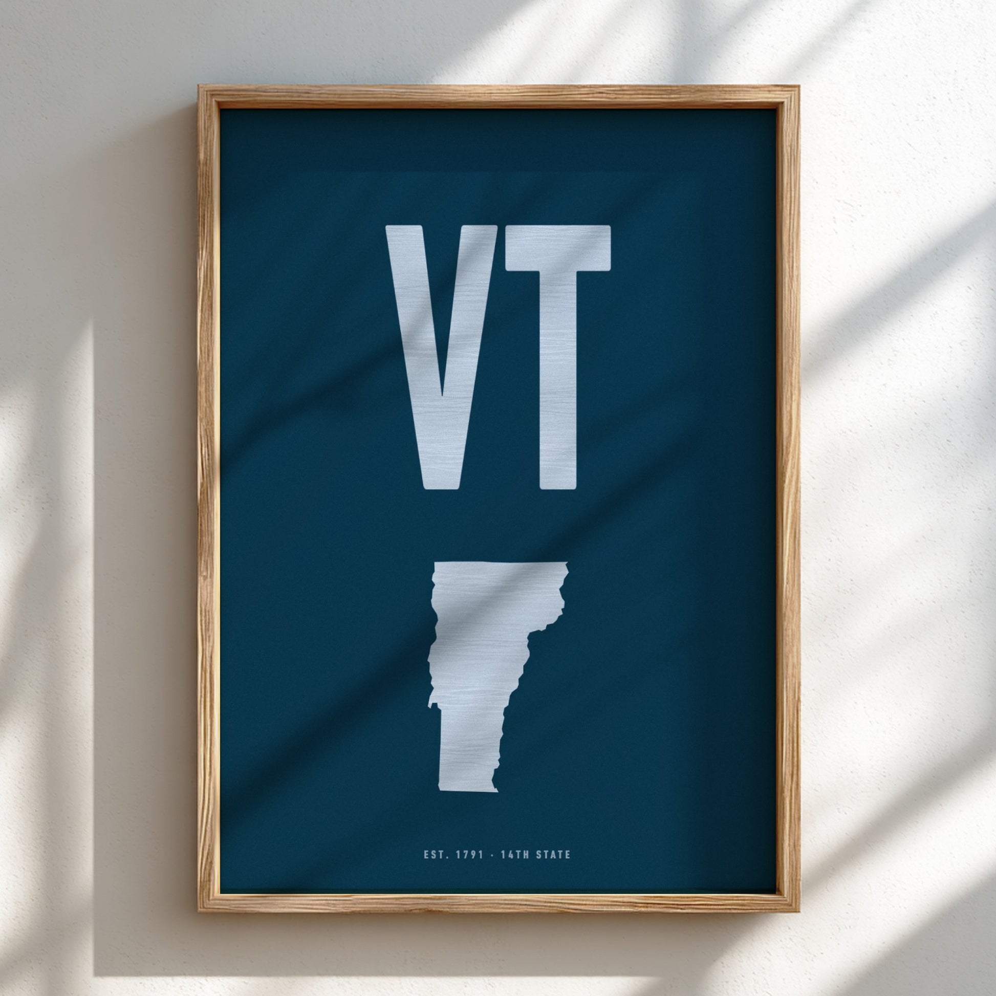 Framed poster with 'VT' initials and a map outline on a dark background