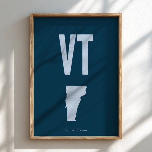 Framed poster with 'VT' initials and a map outline on a dark background