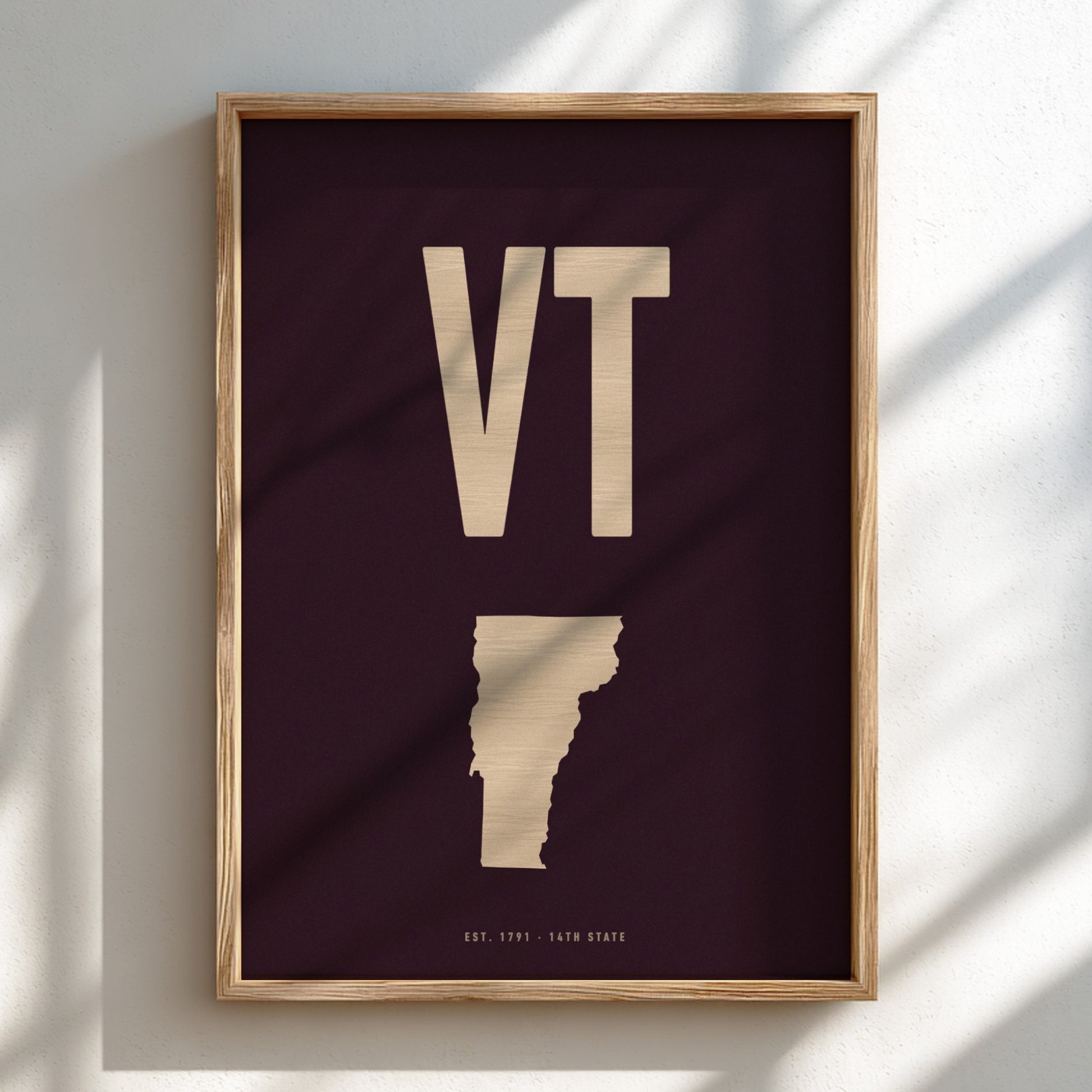 Framed poster with 'VT' initials and a map outline on a dark background