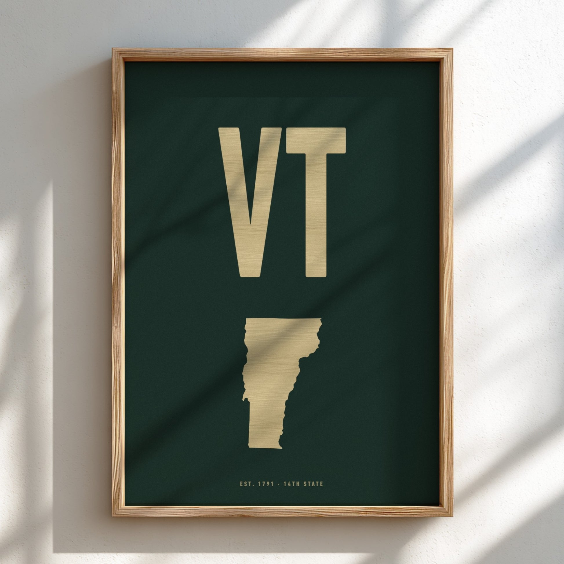 Framed artwork with 'VT' and a map of Vermont on a dark green background