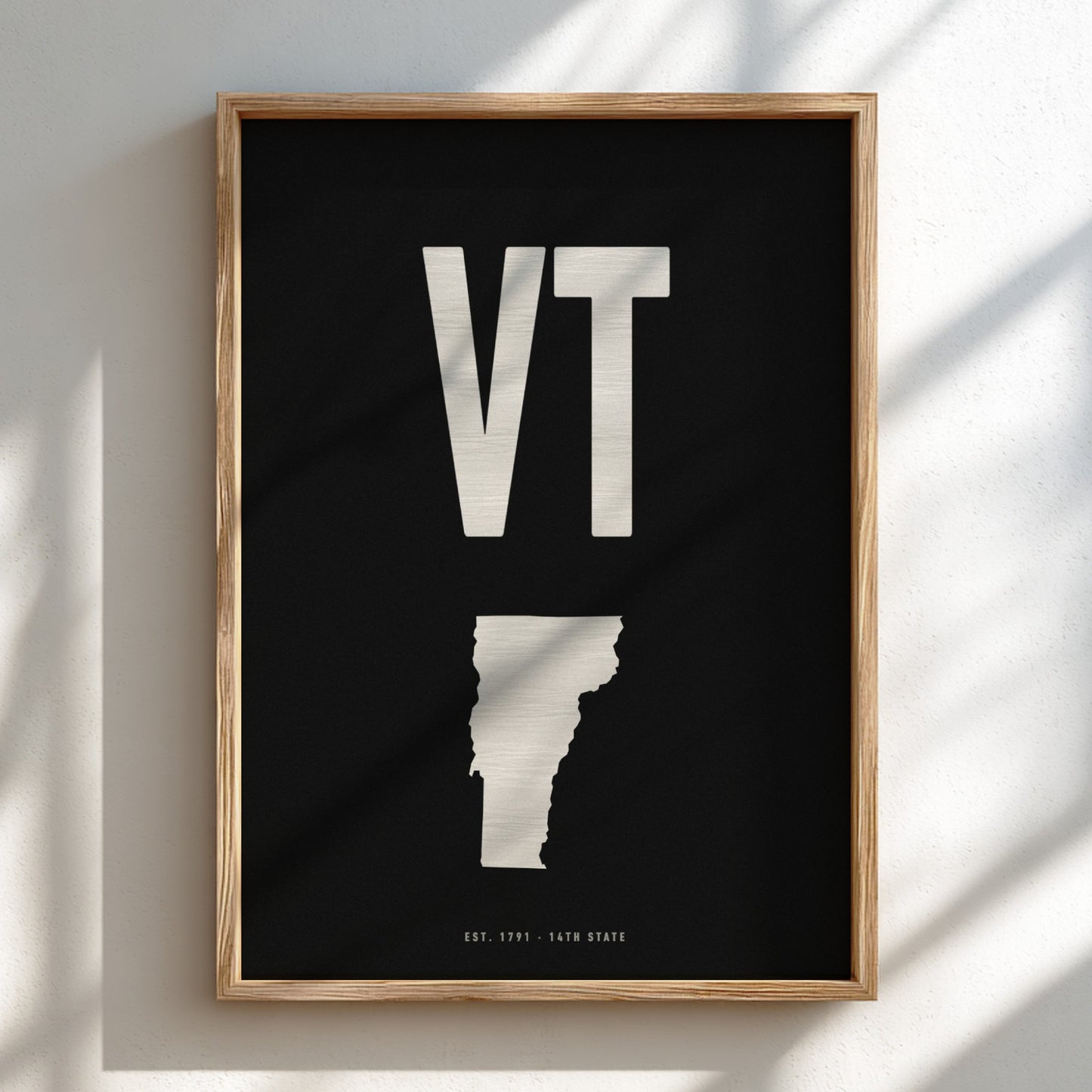 Framed artwork with 'VT' and a state outline on a black background