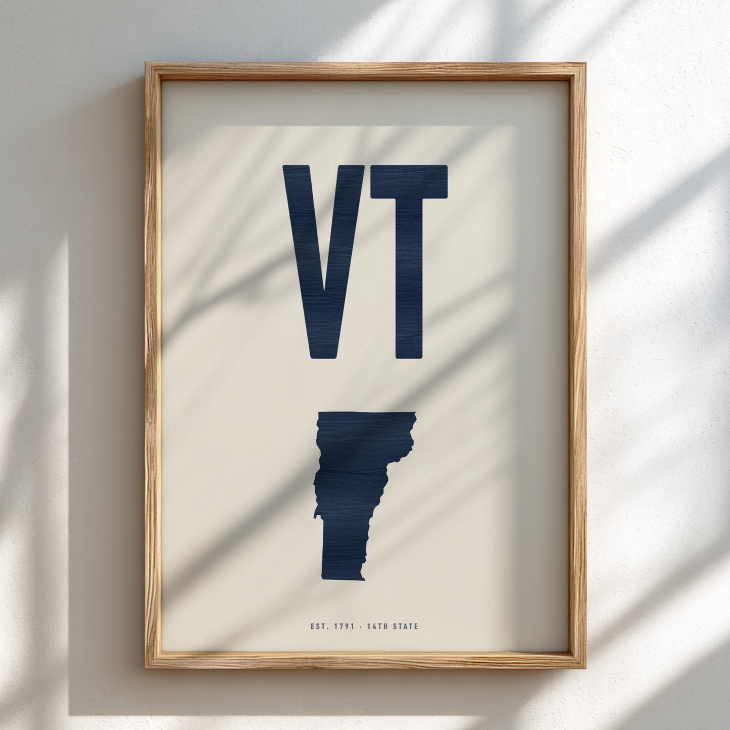 Framed artwork of the state of Vermont with 'VT' on a light background