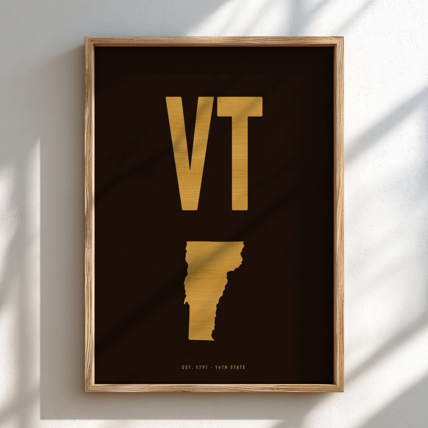 Framed artwork with 'VT' in gold on a black background