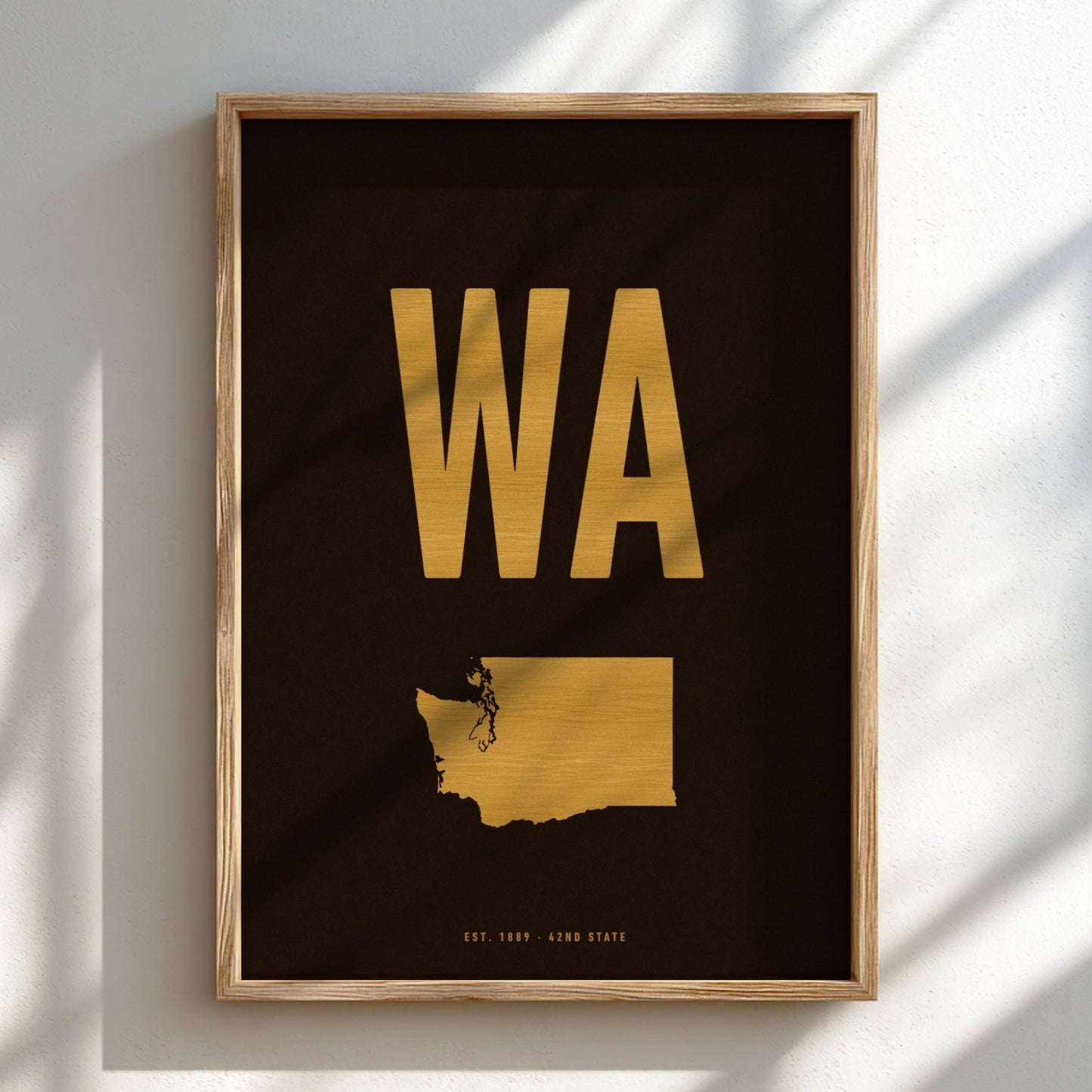 Framed artwork with gold 'WA' and state outline on a black background