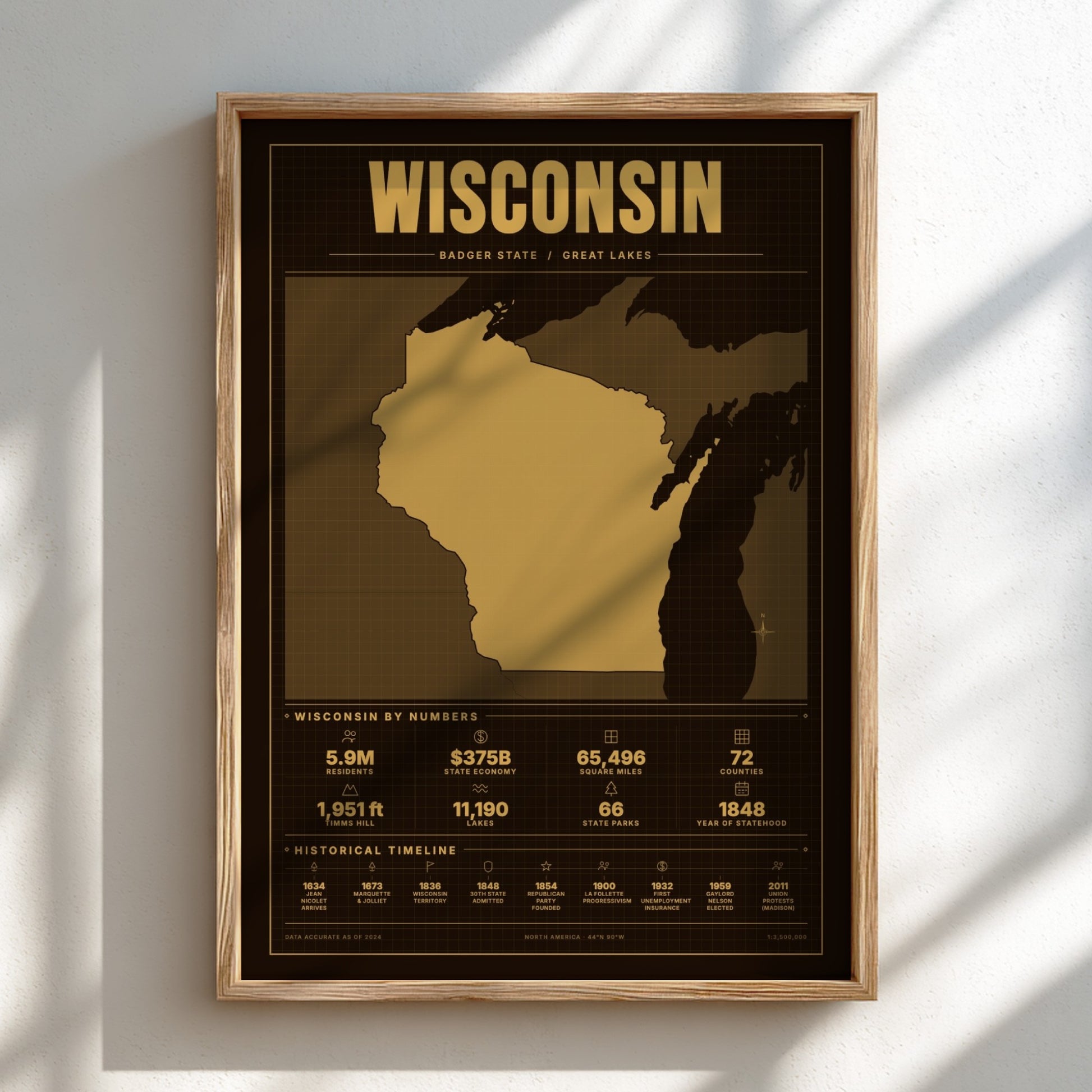 Framed poster of Wisconsin with gold and black design on a white wall.