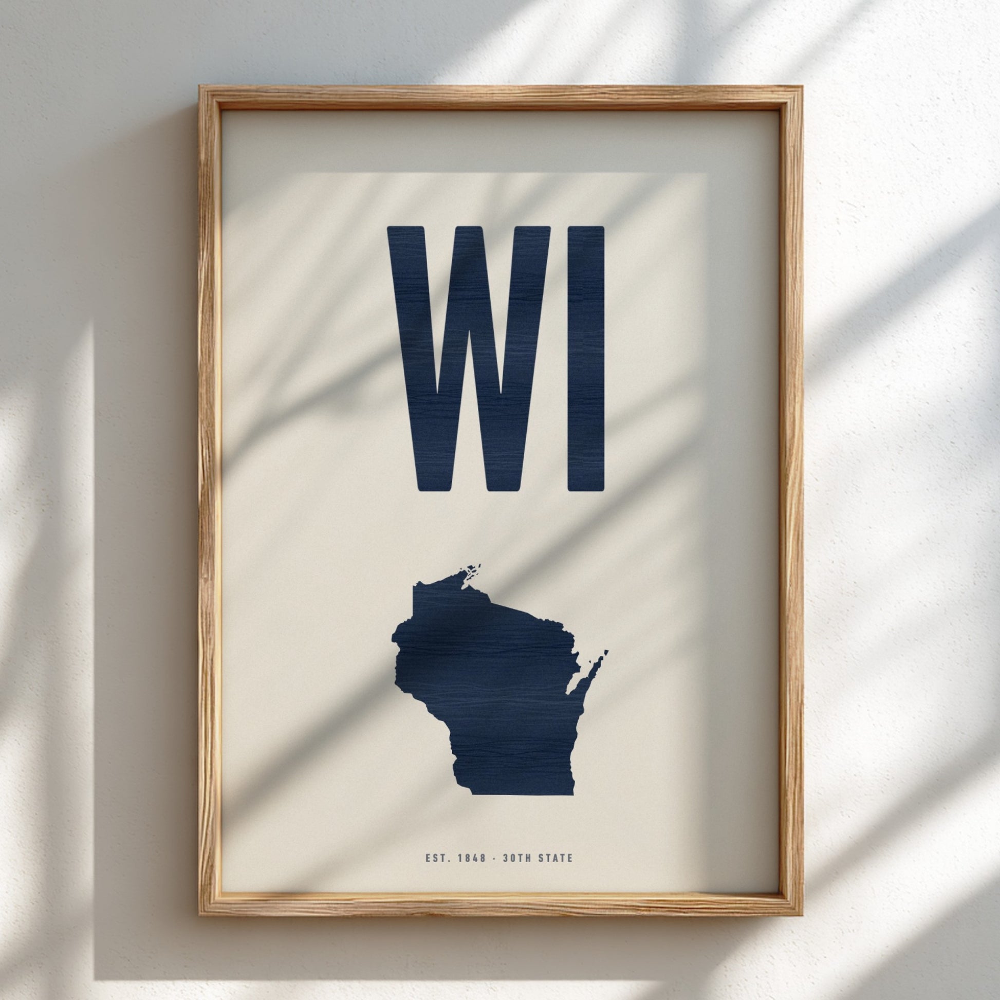 Framed artwork with 'WI' and a map of Wisconsin on a light background