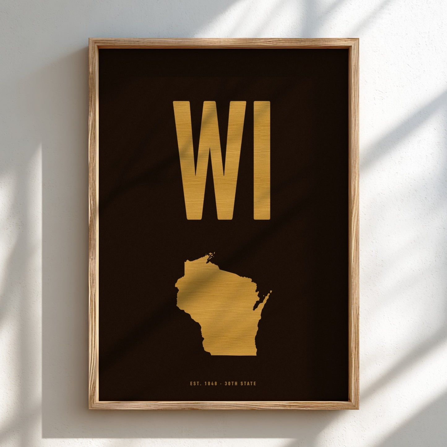 Framed artwork of Wisconsin with 'WI' in gold on a black background