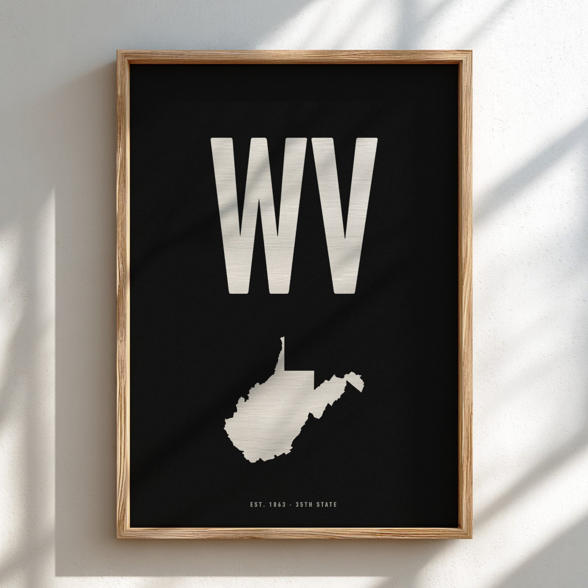 Framed artwork with 'WV' and a map of West Virginia on a black background