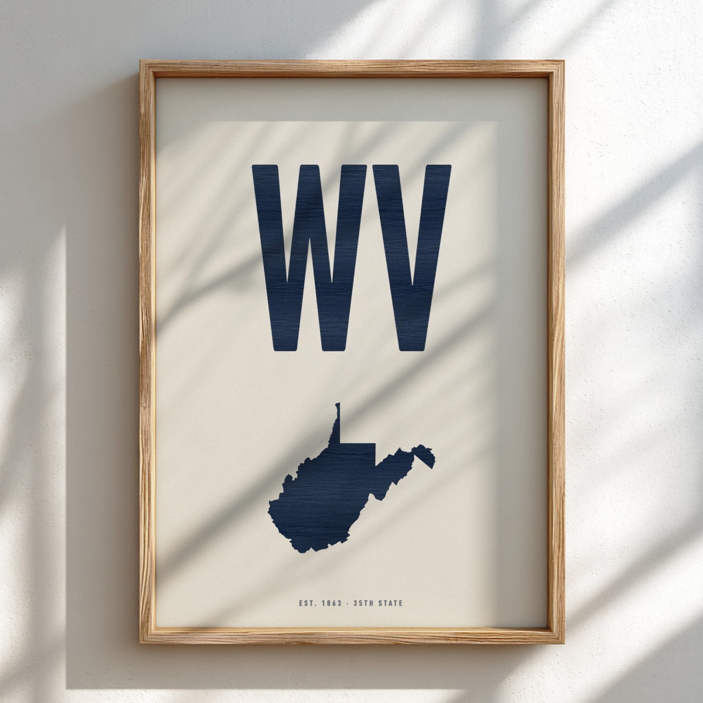 Framed artwork with 'WV' and a map of West Virginia on a light background
