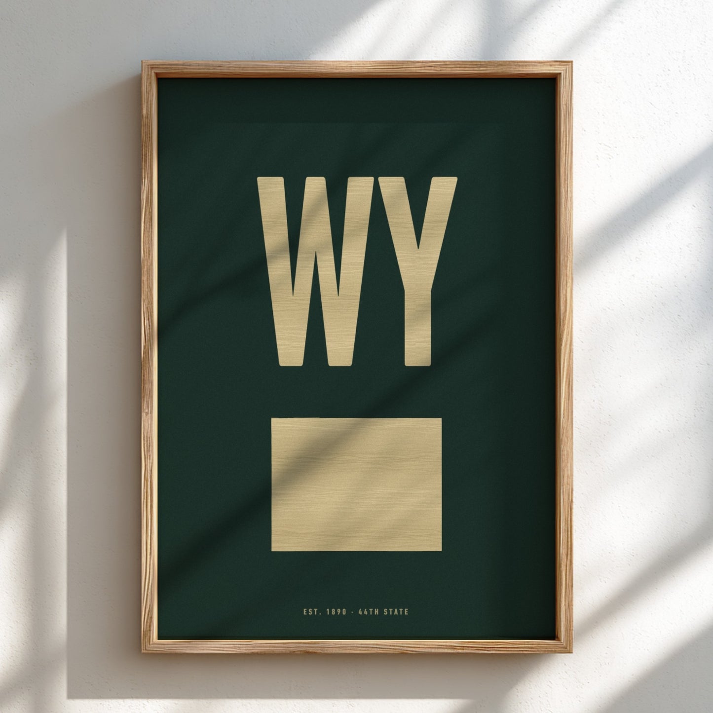 Framed artwork with 'WY' and a map of Wyoming on a dark green background